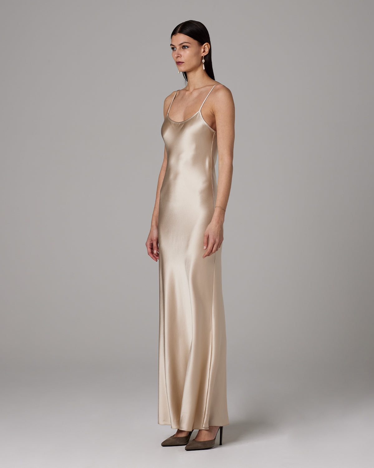 Model wearing a Liquid Silk Slipdress in a neutral color, side view