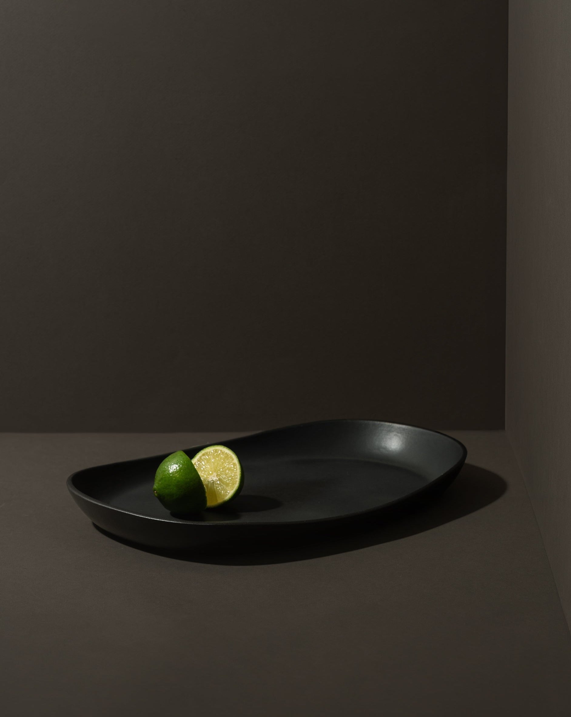Mini stoneware serving platter with a selection of pastries and blackberries on a kitchen countertop.