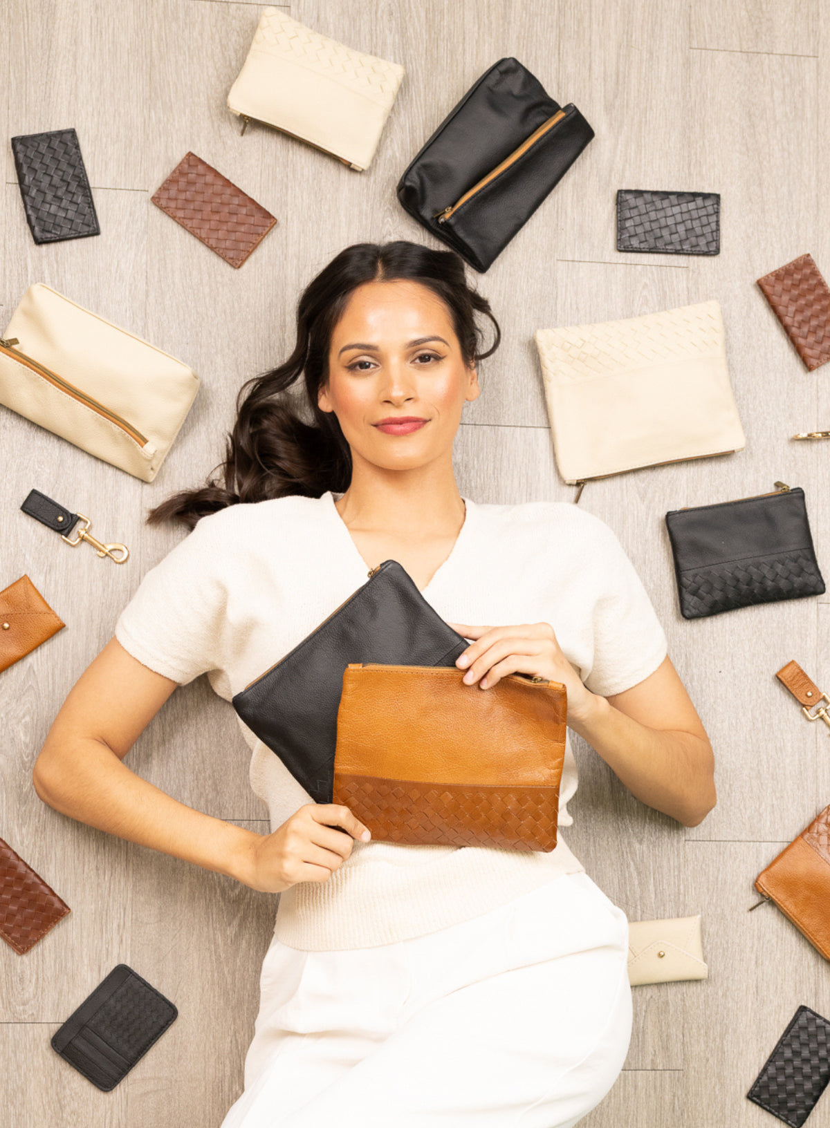 model lying down surrounded by our leather accessories.