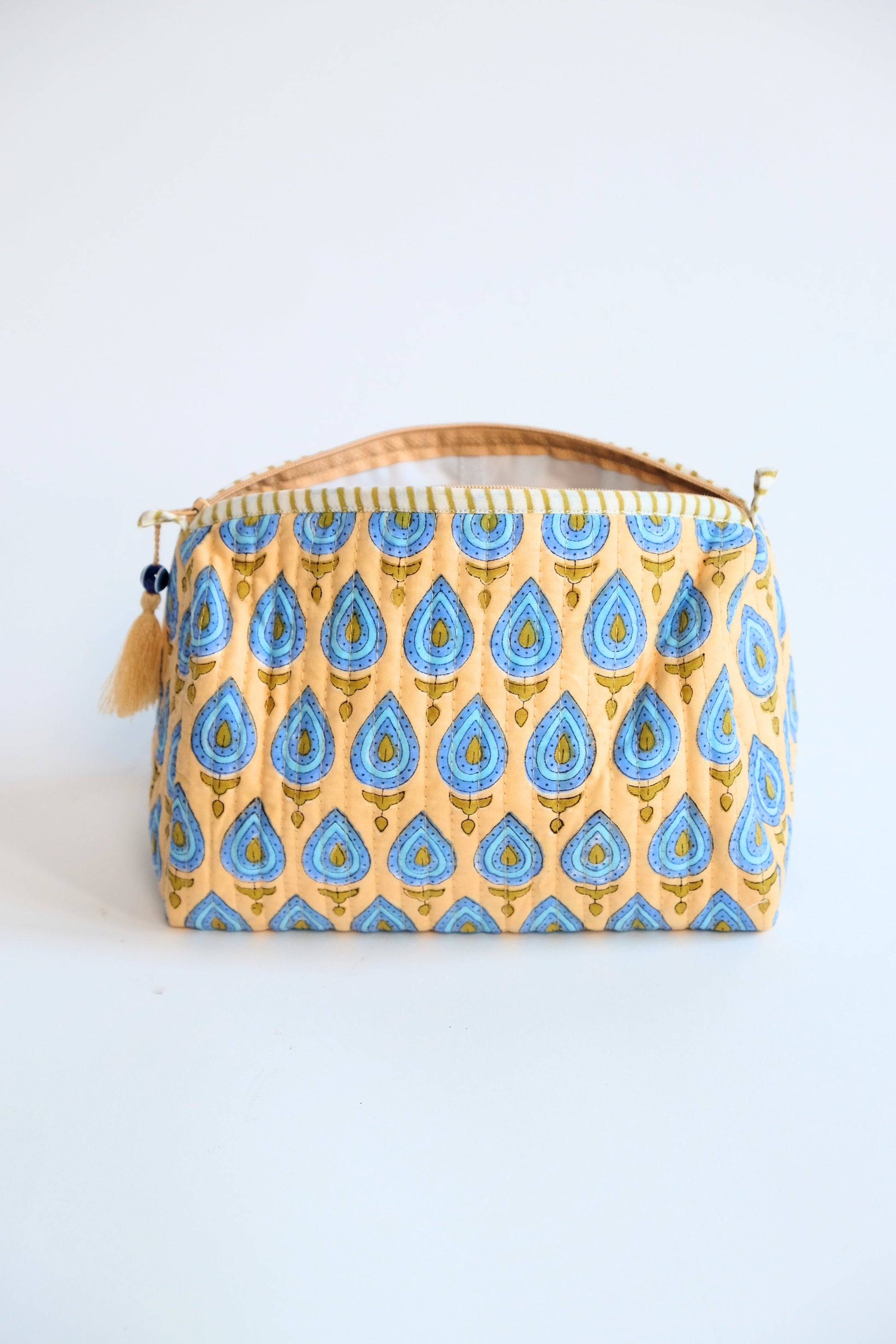 Front view of beige evil eye pattern toiletry bag with zipper handle - Inner Child