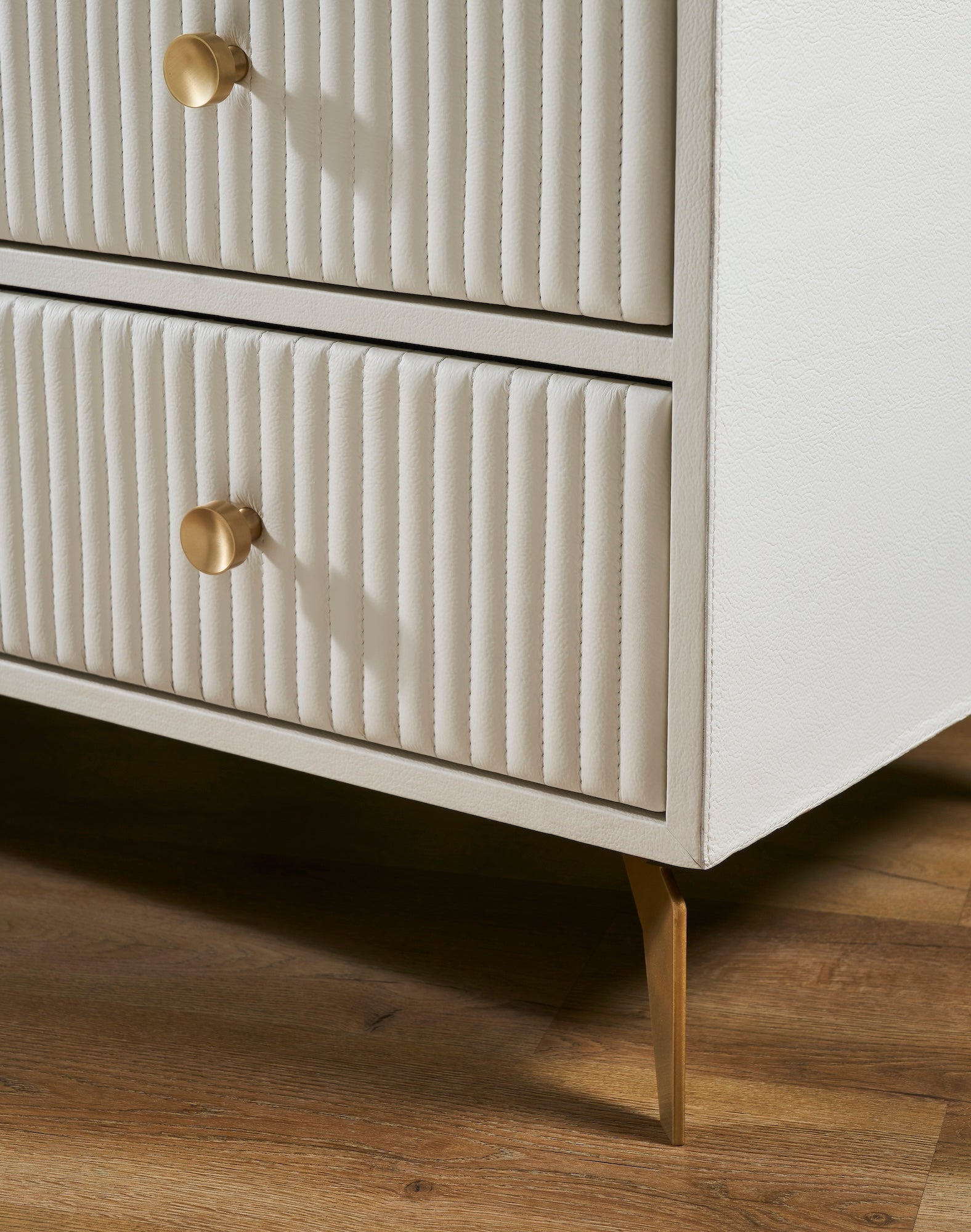 FN-5216-482036_5|Detail of white ribbed leather texture and sleek gold tapered legs, highlighting luxury furniture craftsmanship and modern design.