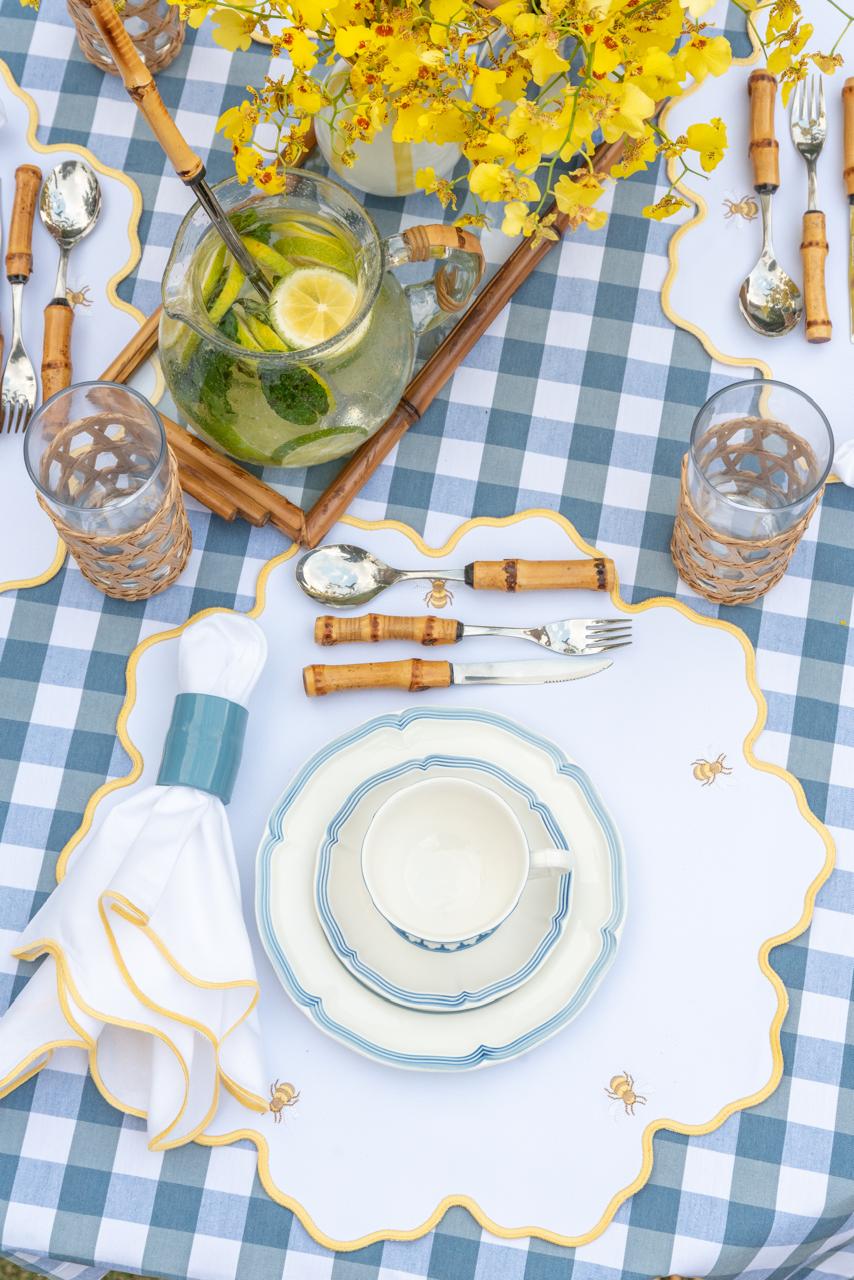 Bumble bee impermeable placemat with hand-stitched bee embroidery and yellow wavy border by Talah Home