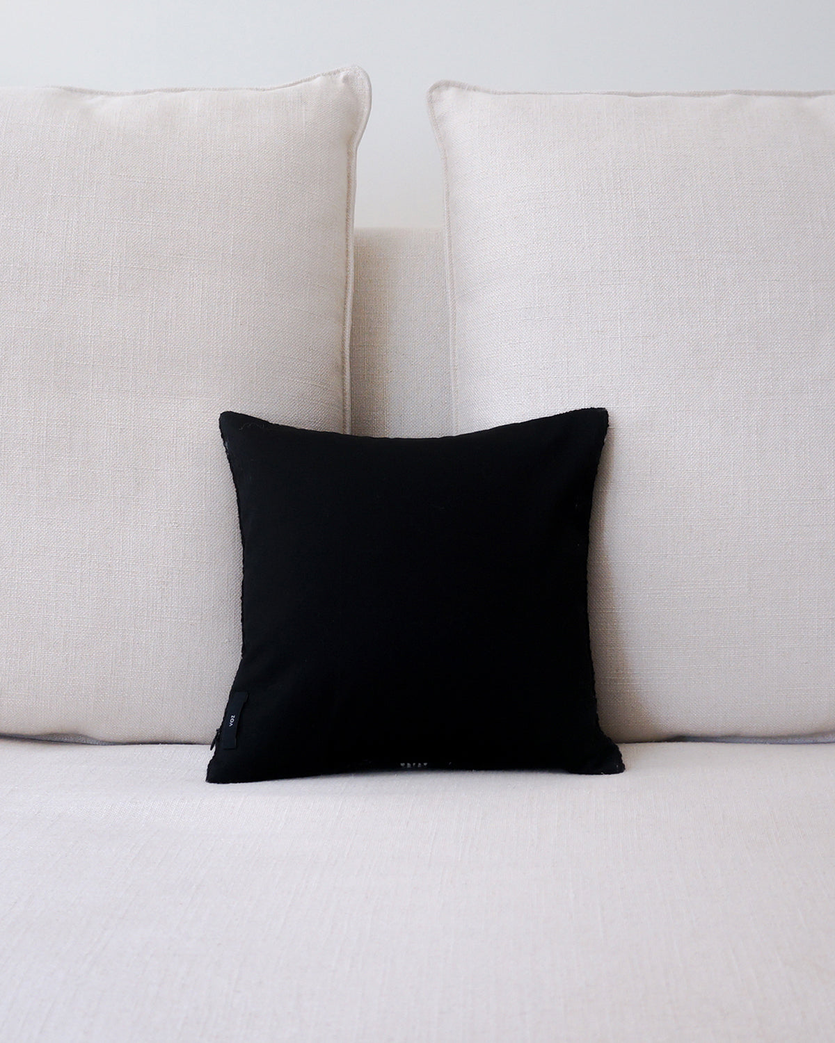 Black Centro Lineas Square Small Pillow on a light-colored couch