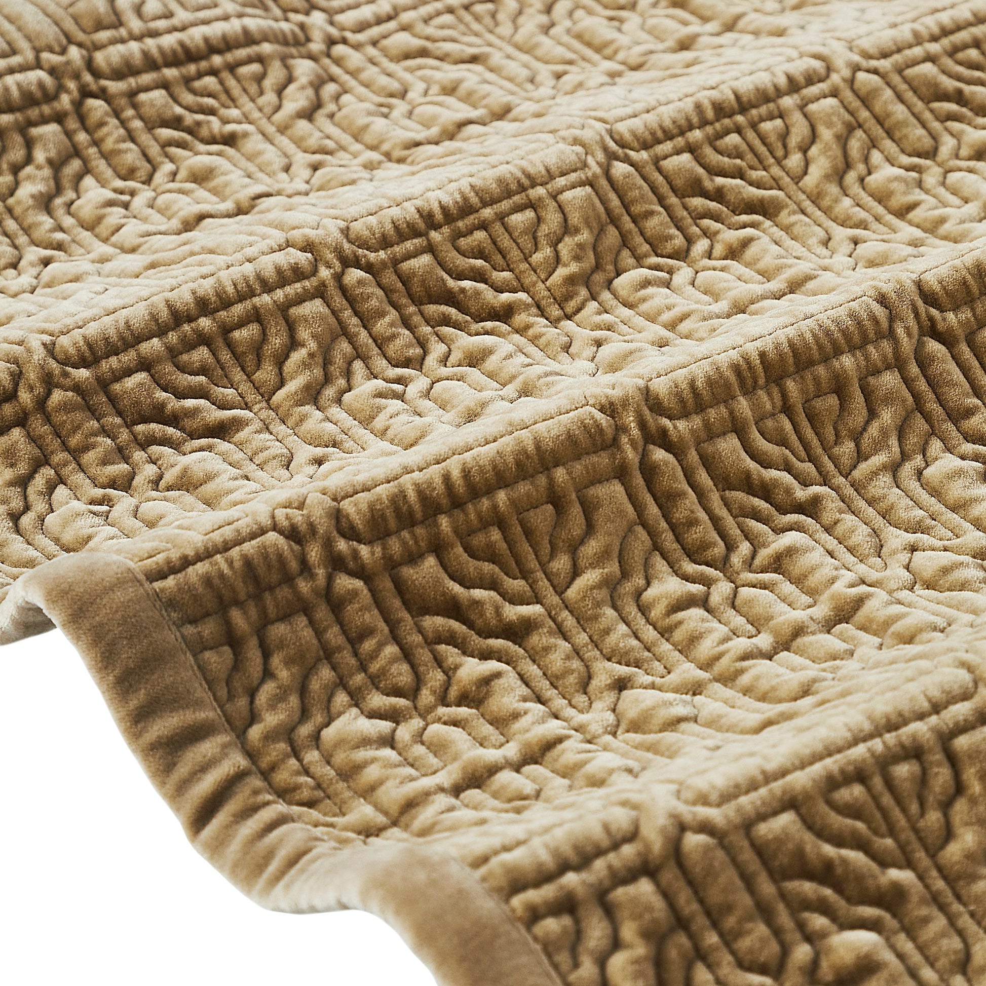 QT-377-9496_7|Detailed close-up of a tan quilted bedspread's corner, highlighting its embossed geometric pattern and soft, luxurious texture.
