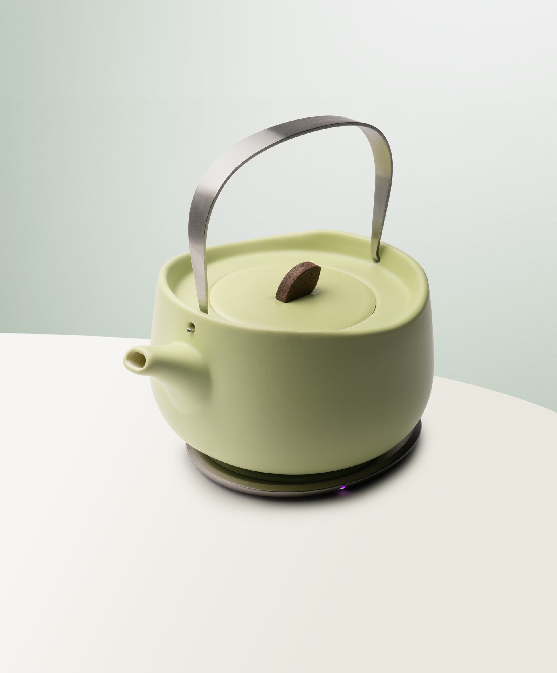 Leiph Self-Heating Ceramic Teapot Set 20 fl oz / 600 mL in Verde Green angled top-side view on OHOM Charging Pad 3