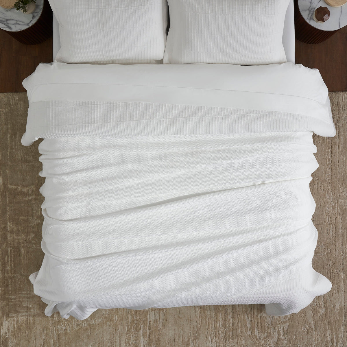 BL-865-11096_4|Overhead view of a soft, textured white blanket fully covering a cozy bed, showcasing its elegant pattern and inviting warmth.