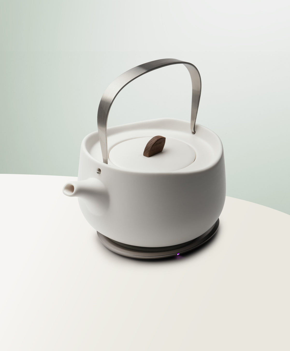 Leiph Self-Heating Ceramic Teapot Set 20 fl oz / 600 mL in Jasmine White angled top-side view on OHOM Charging Pad 3