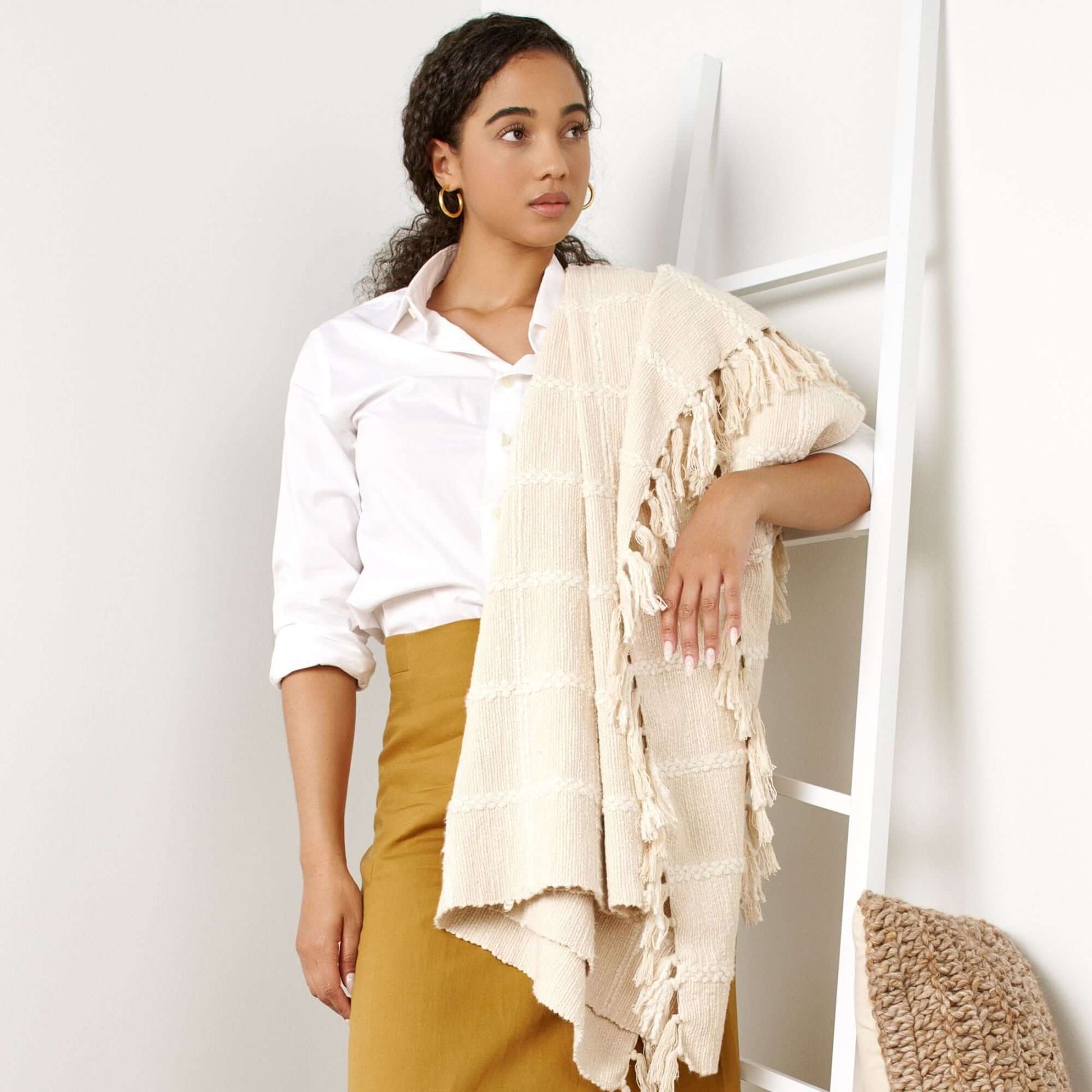 Woman draped in Sea Shell White Textured Checks Handloom Throw, showcasing its elegant design and hand-rolled fringes.