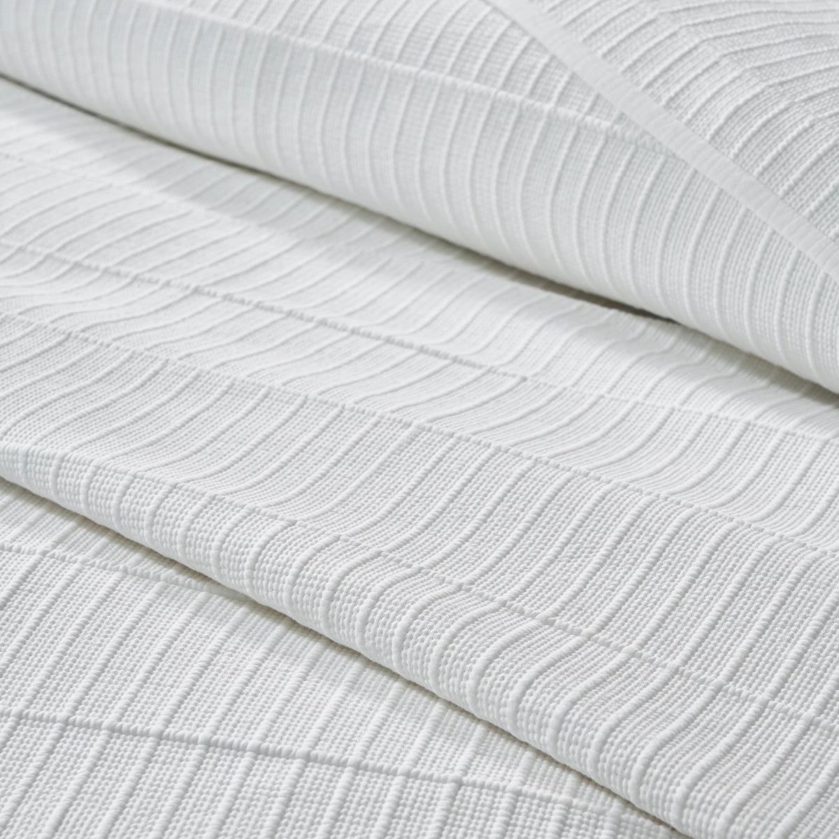 CL-268-9496_6|Detailed close-up of a premium white textured coverlet fabric, showcasing its intricate striped pattern and soft weave.
