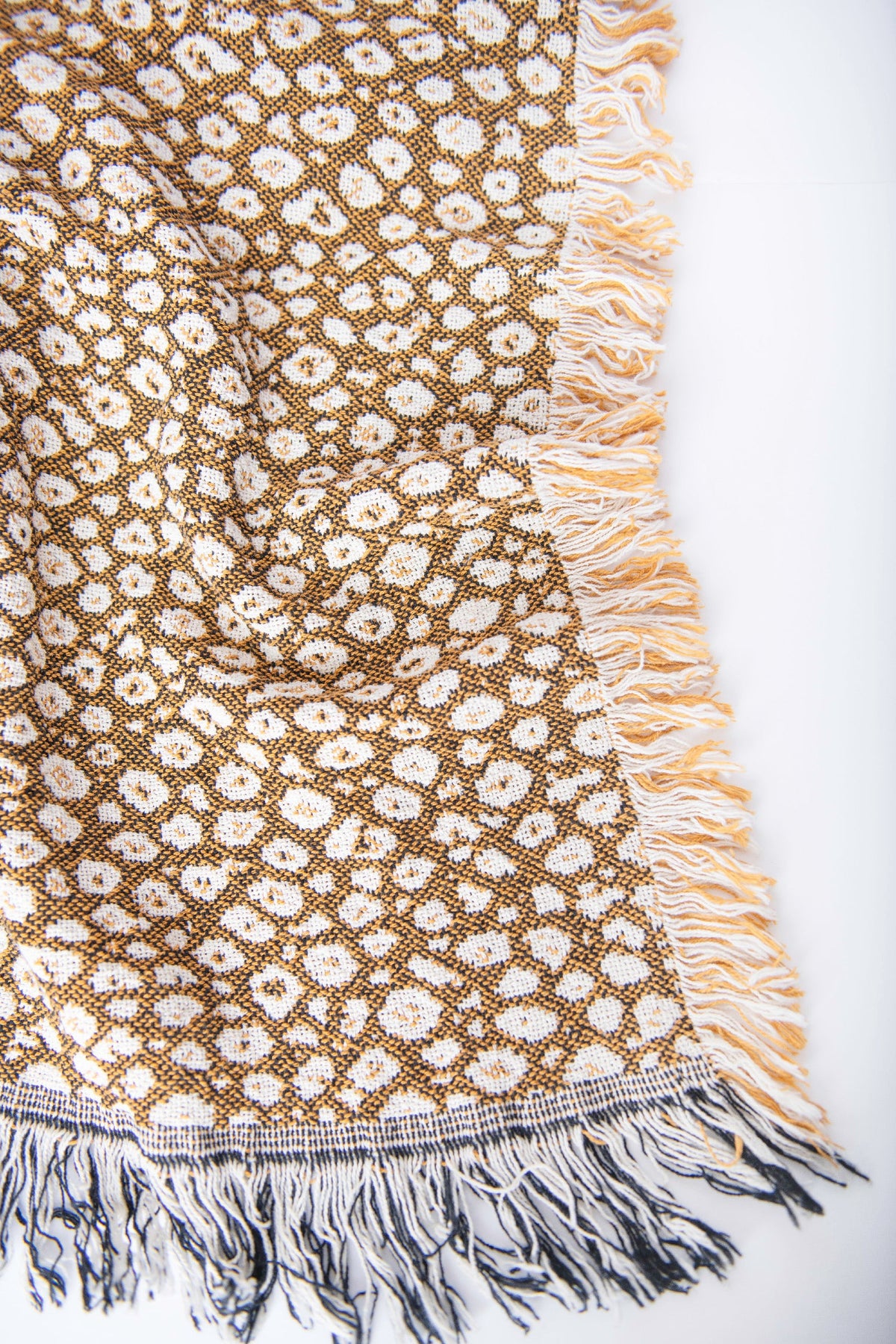 Close-up of the darker reverse side of the Zola golden leopard-print woven throw