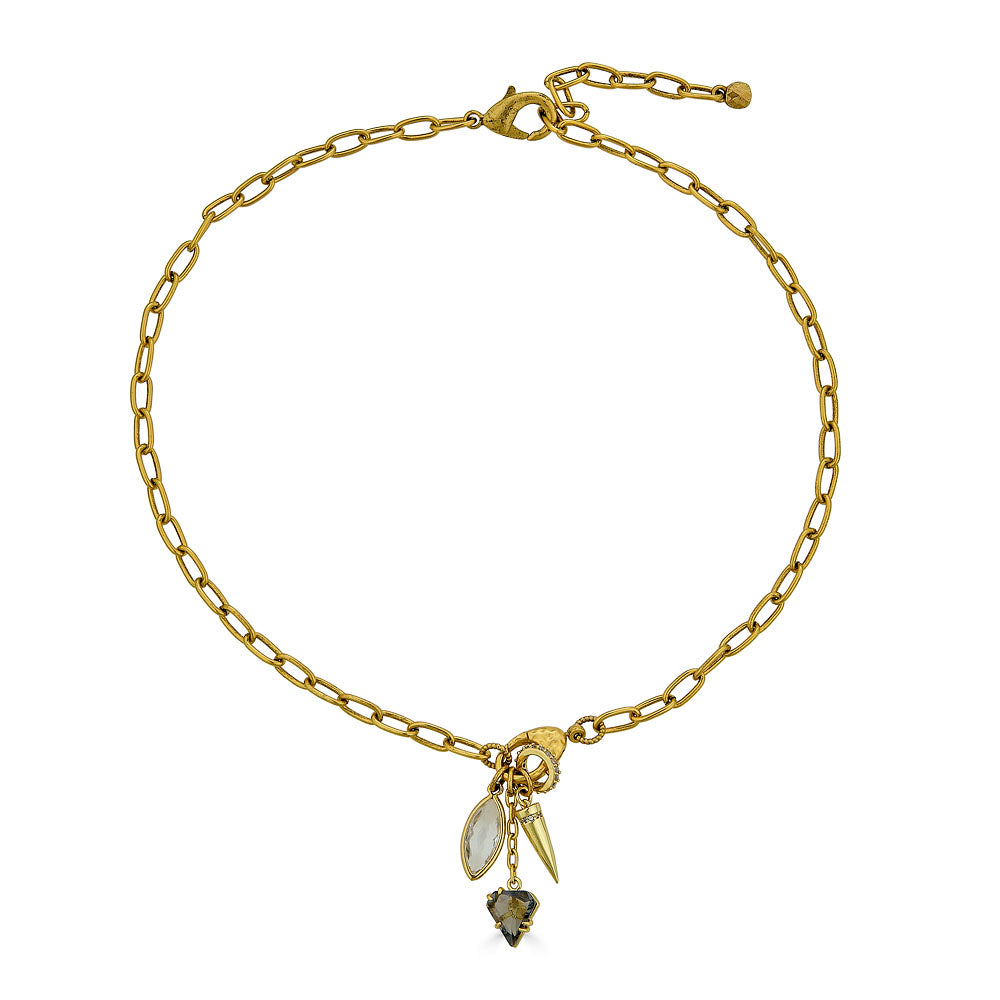 Gold necklace with marquise crystal, spike charm, and smoky gem drop on a textured clasp