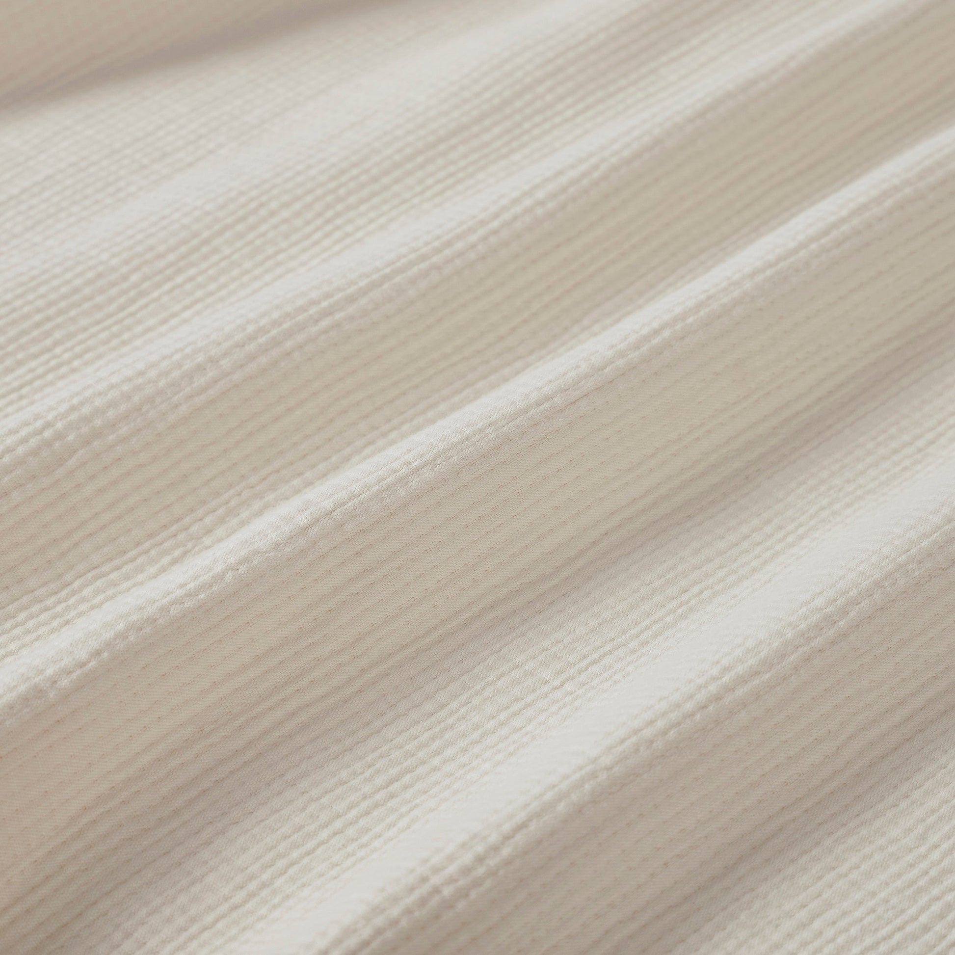 BL-860-9496_9|Detailed close-up of a soft light beige waffle weave blanket fabric, highlighting the texture and quality material.