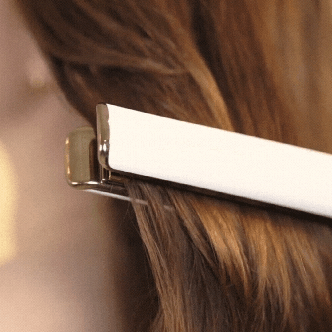 model with brown hair using a heat styling tool hair straightener after using rahua heat protectant shield|variant:2-oz,65-oz