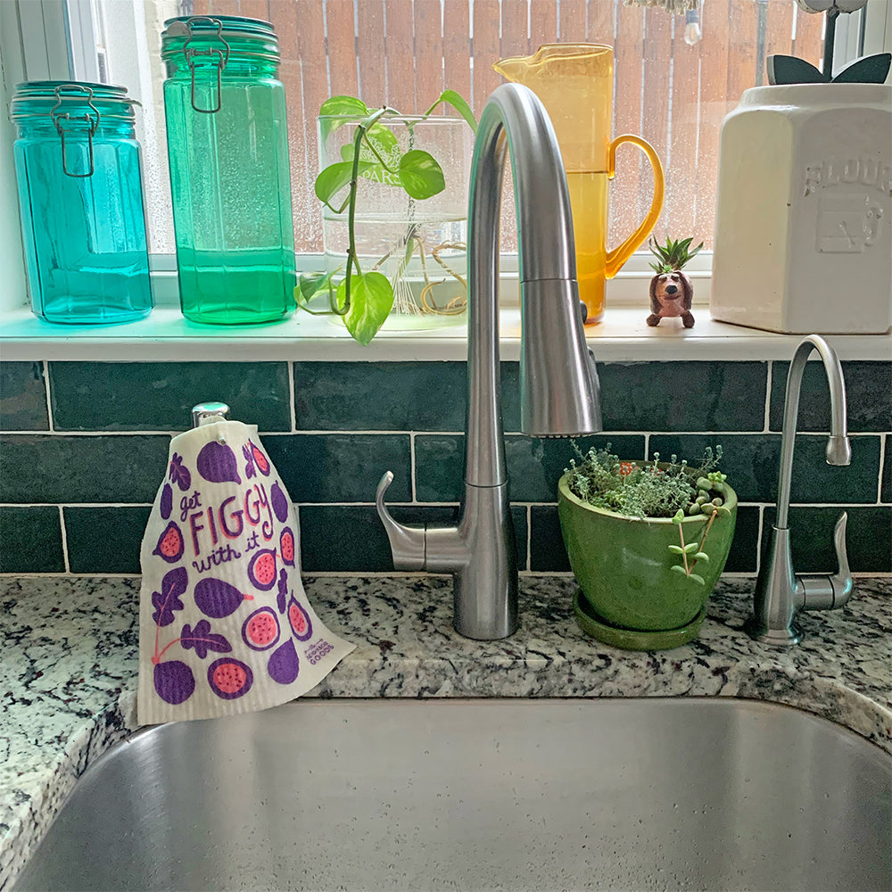 A fig sponge cloth hangs to dry on hand soap dispenser.