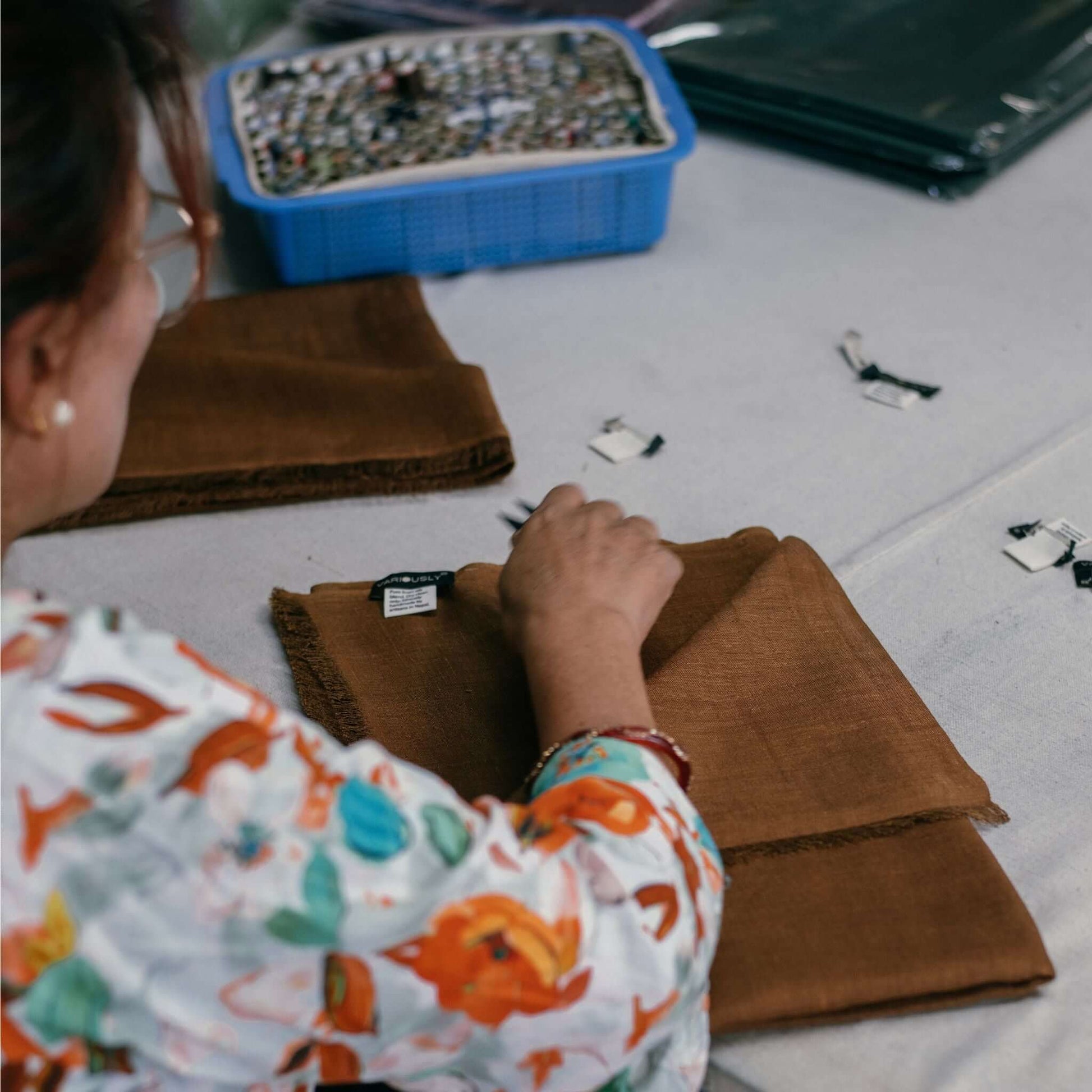 Coco Brown Hand Woven Linen Silk Blend Scarf being prepared by an artisan with a beautiful hand-stitched finish.