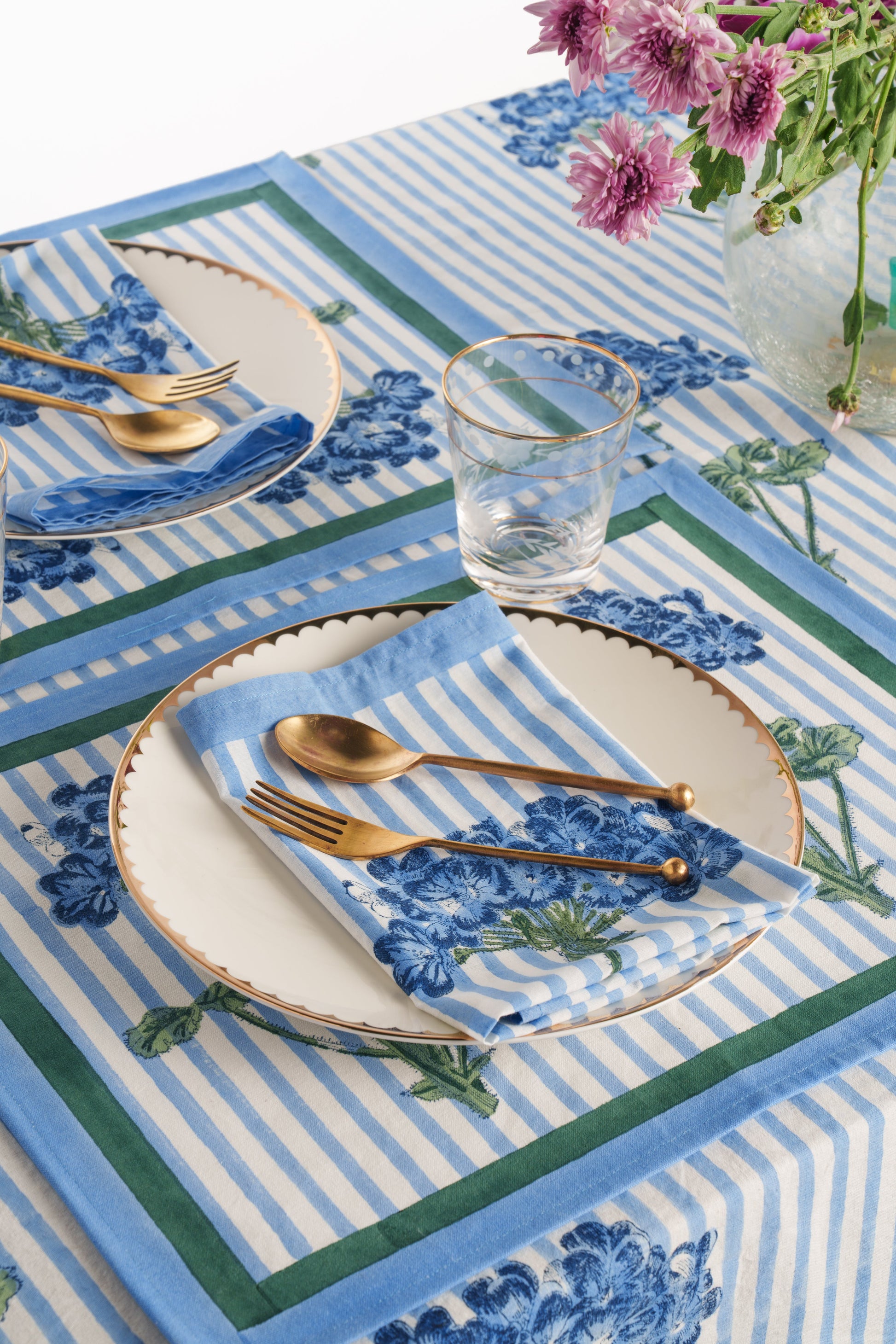 Blue hydrangea blockprint placemat in dining setup with copper plates