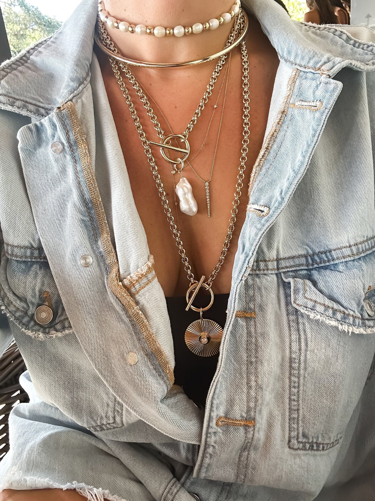 Layered gold necklaces featuring the Micro Royal Toggle and XL Baroque Pearl Pendant