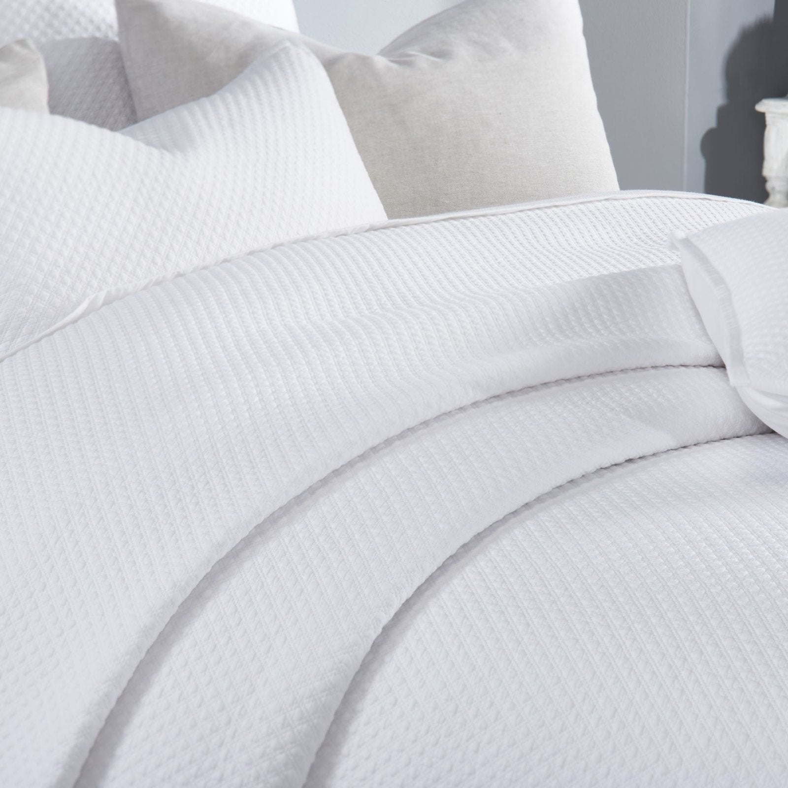 CL-200-9496_4|Detailed view of the pristine white quilted coverlet, highlighting its exquisite diamond pattern and soft fabric.
