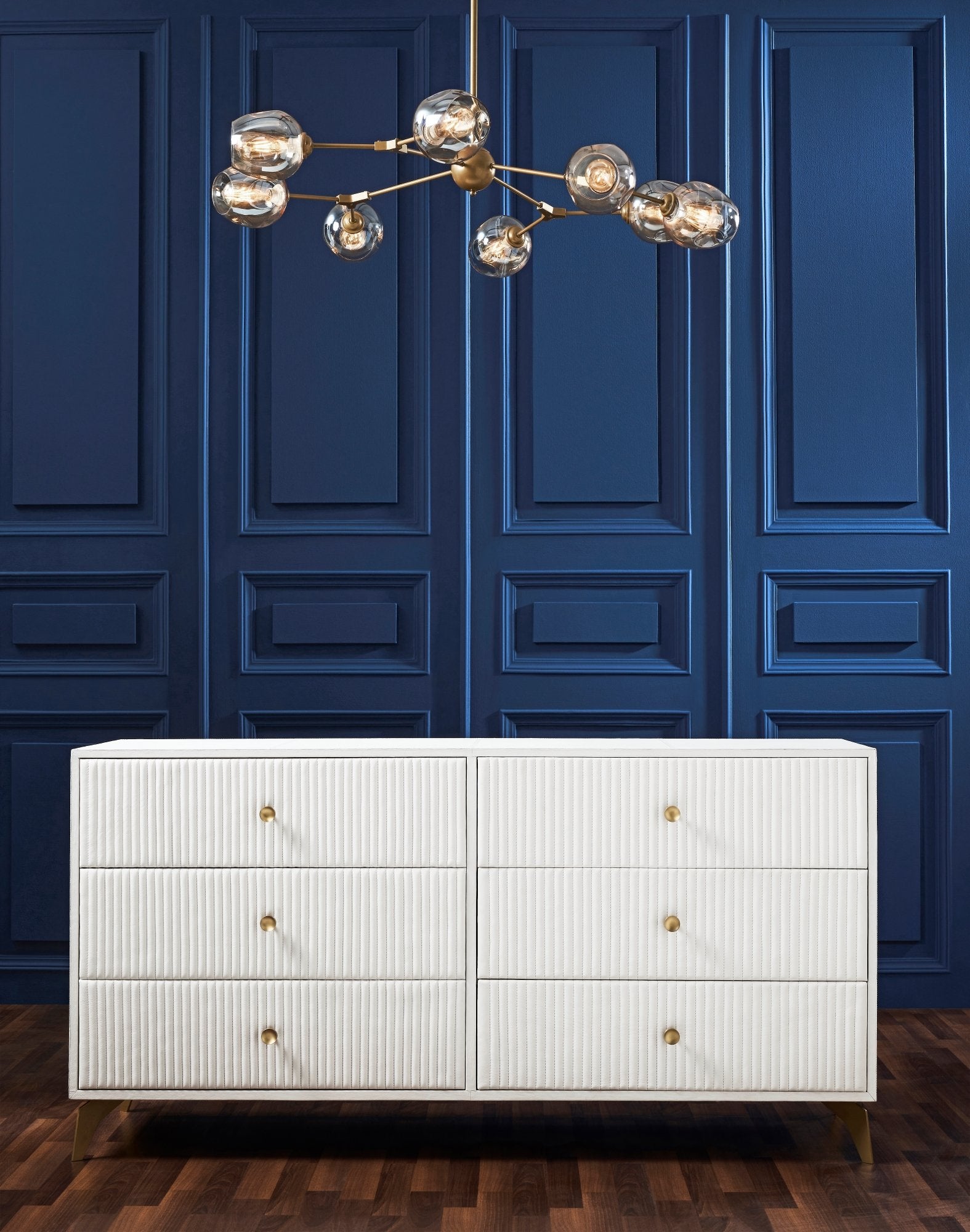 FN-5203-642033_2|White leather six-drawer dresser with ridged texture and gold pulls in a room with blue paneled walls, luxury furniture.