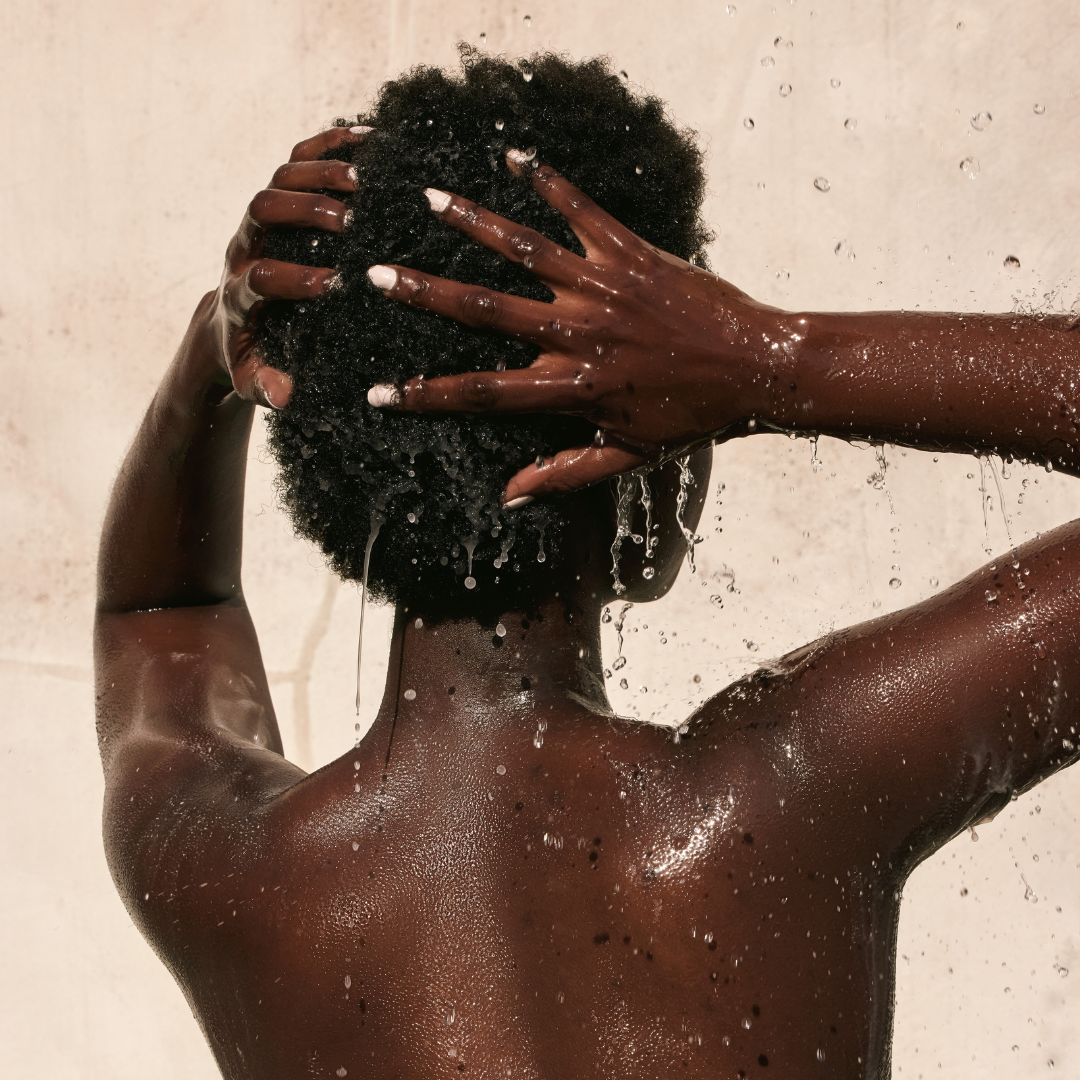 Woman shampooing her hair with Cote Beauty Nourishing Daily Shampoo
