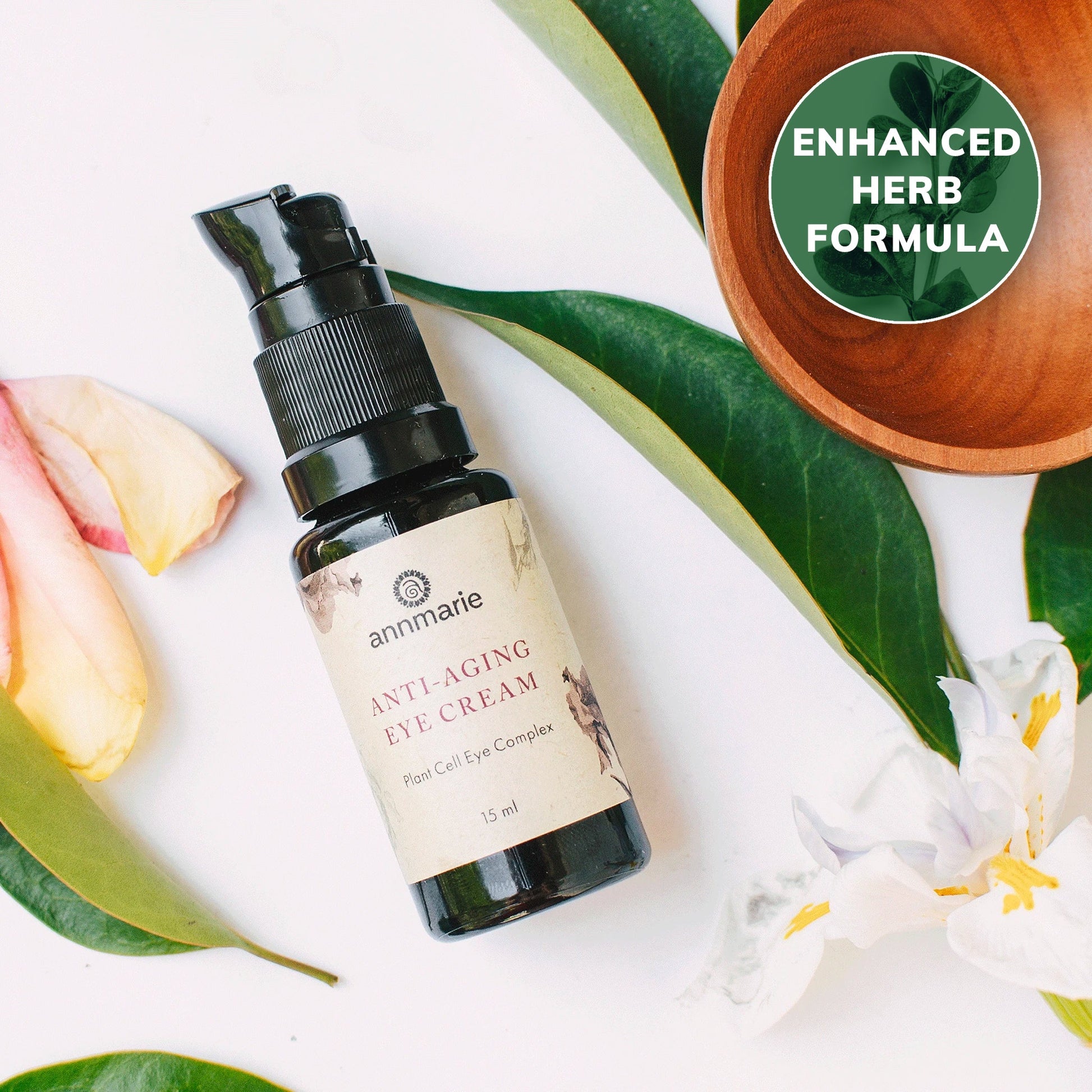 Anti-Aging Eye Cream with plant cell eye complex in a 15 ml pump bottle surrounded by botanical leaves and flowers with enhanced herb formula badge.