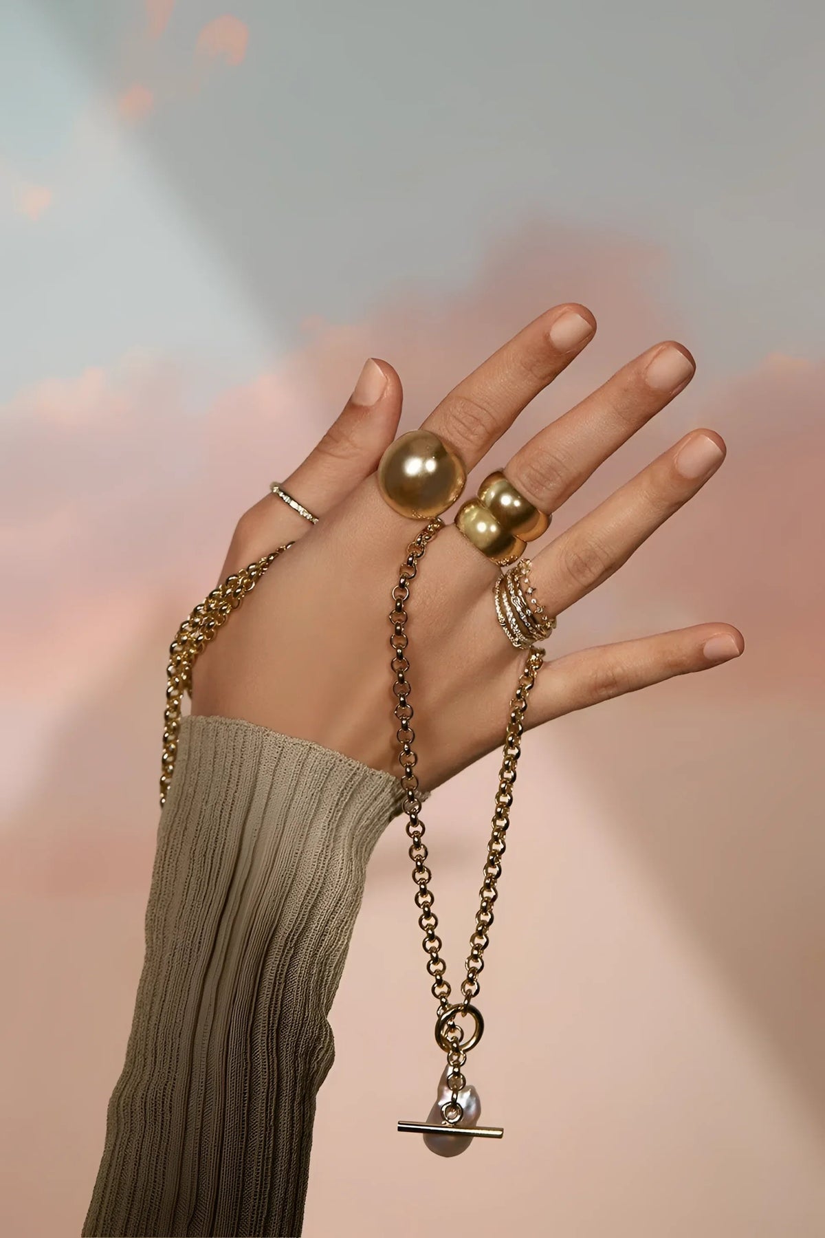 Hand with gold jewelry wearing Micro Royal Toggle & XL Baroque Pearl Pendant Necklace