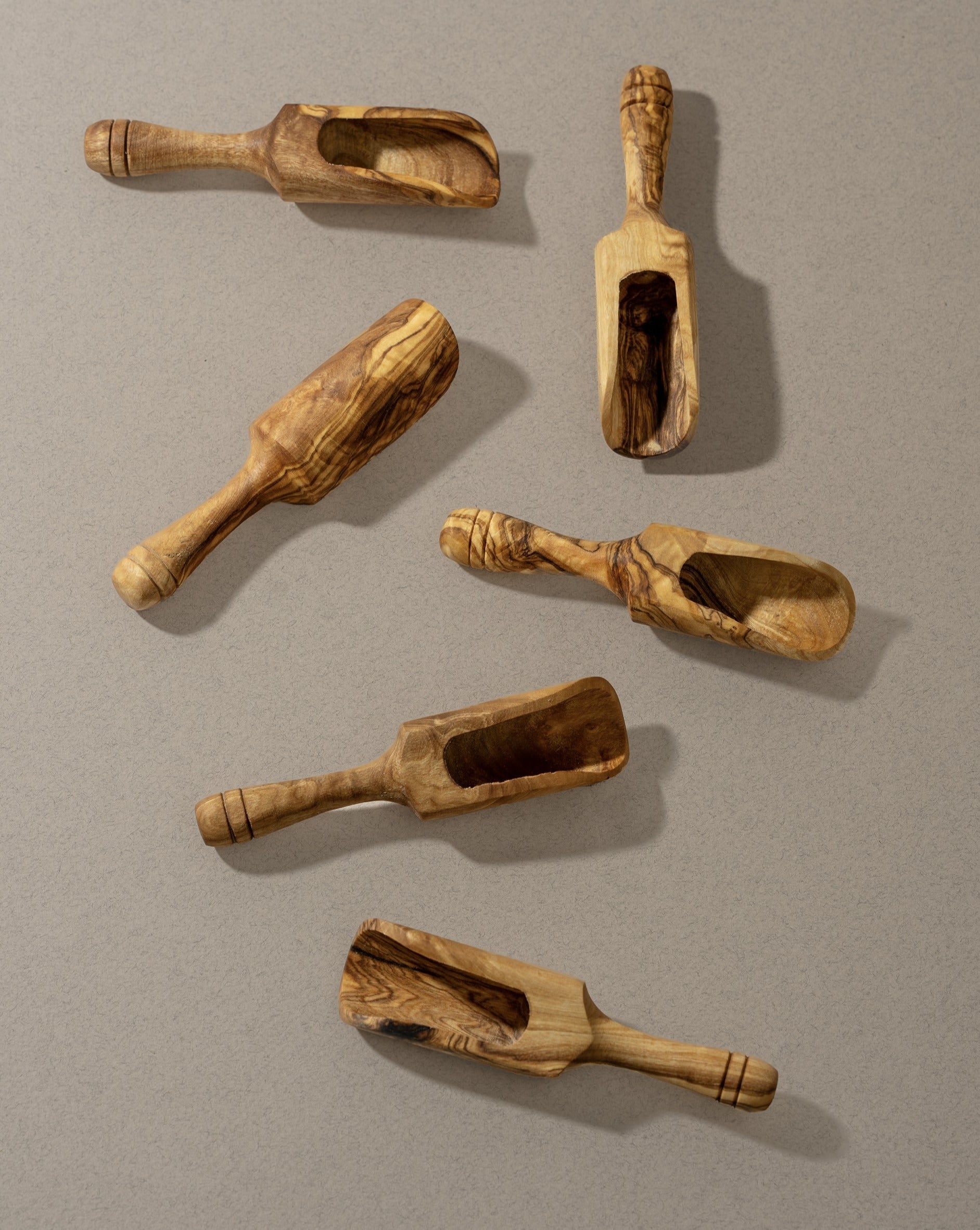 A collection of wooden scoops of various sizes, displayed against a neutral background.