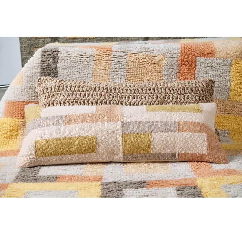 Shale Hand Woven Pastel Color Large Geometric Lumbar Pillow displayed on a cozy textured blanket.