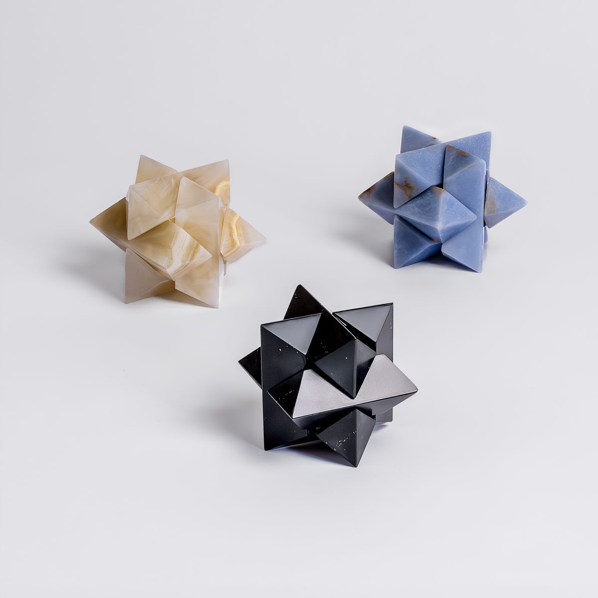 Collection of assembled burr star puzzles in various natural Andean stones displaying their geometric harmony.