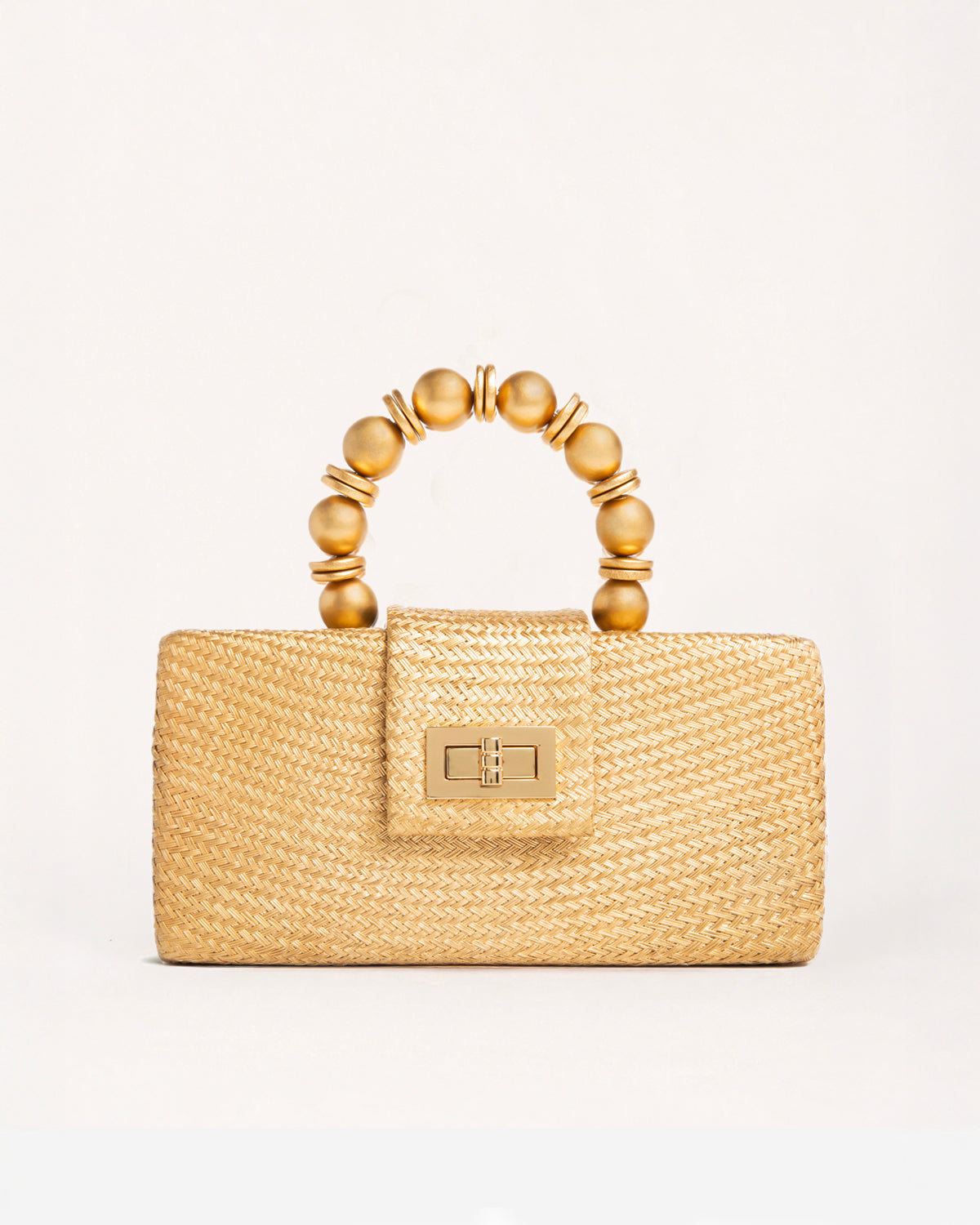 A structured straw handbag in a warm gold tone, featuring a top handle made of glossy gold-toned beads and a gold-tone turn-lock clasp on the front flap.