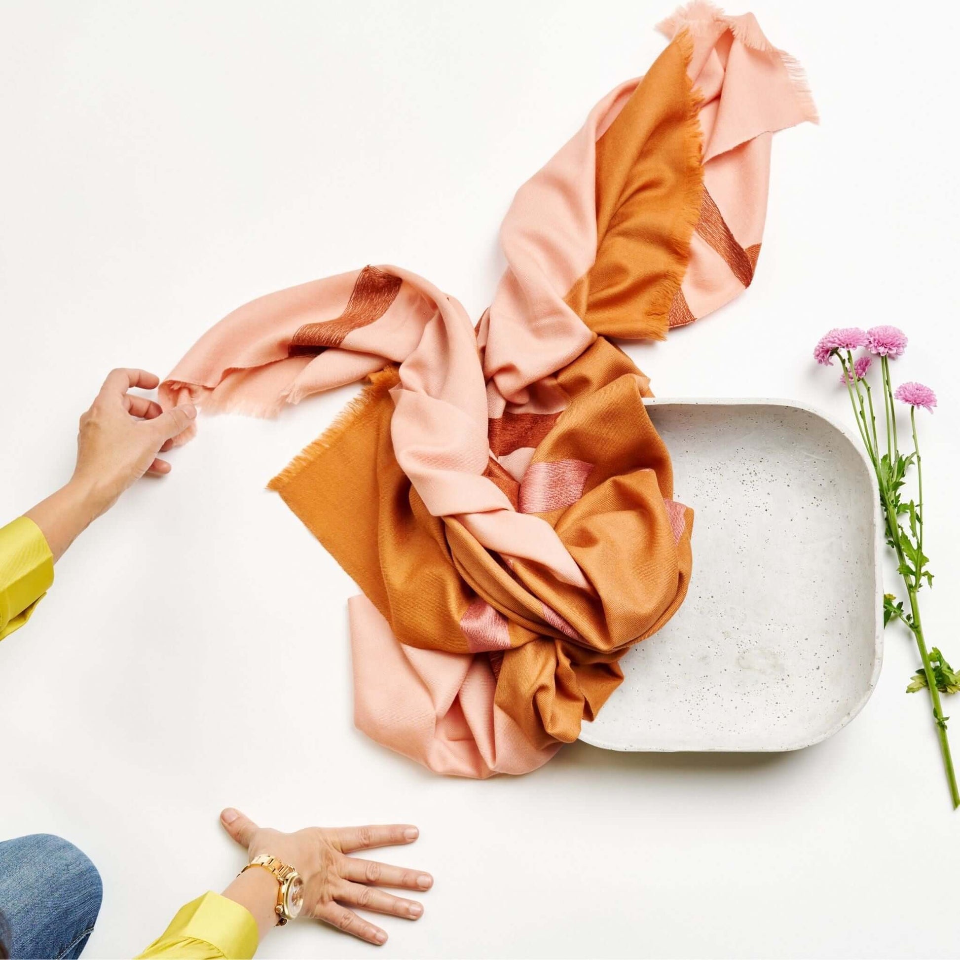 Canyon Hand Embroidered Hand Woven Merino Silk Soft Scarf displayed on a textured surface with pink flowers.