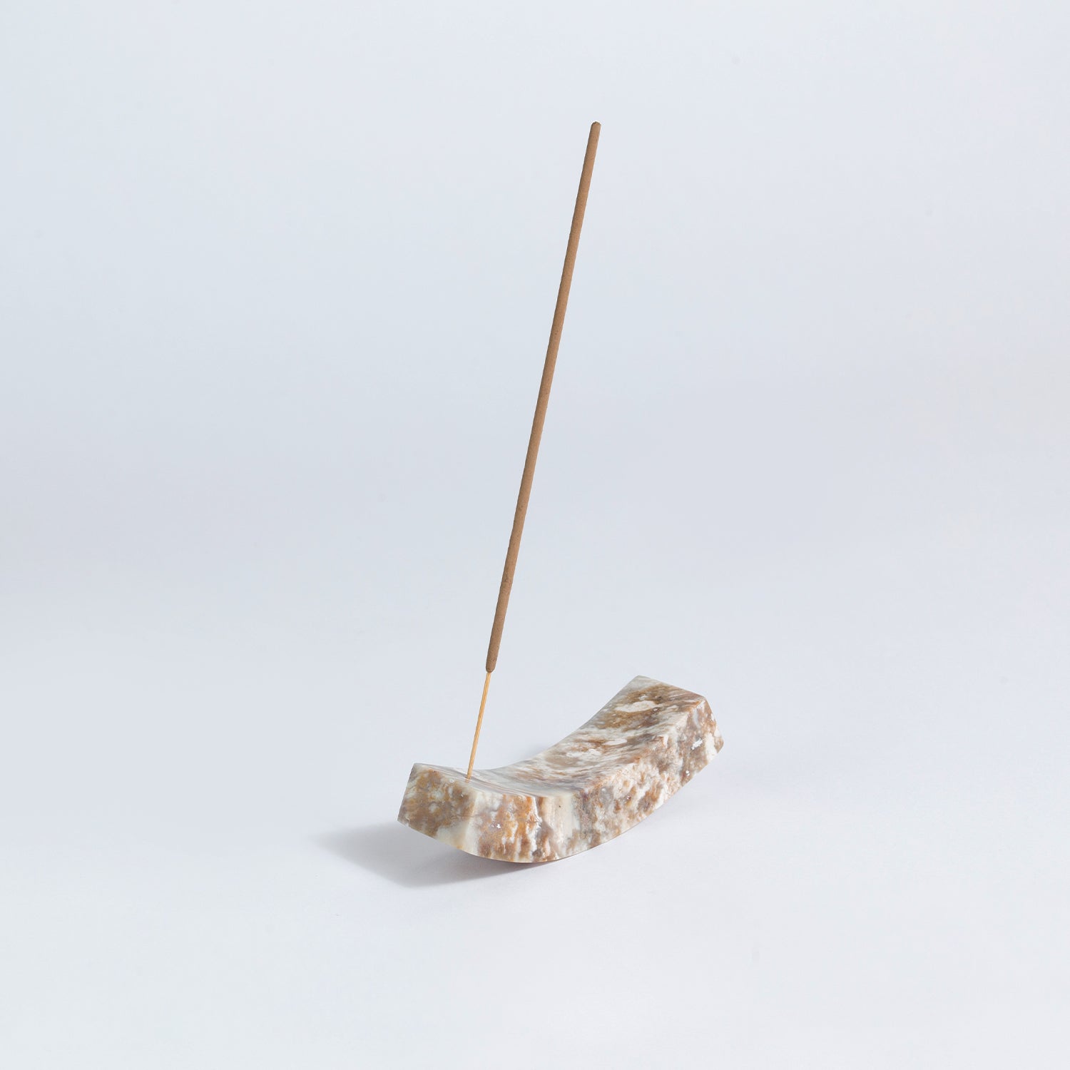 Creamy soapstone smile incense holder displaying warm, organic tones on a white background.