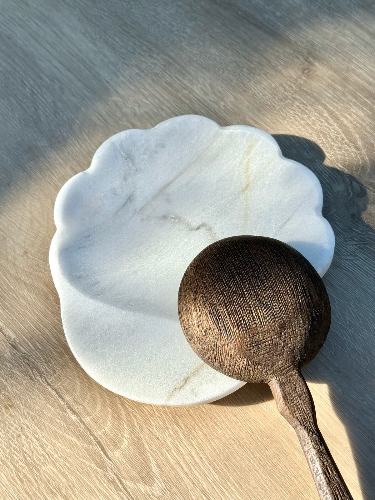 Handcrafted white marble spoon rest featuring organic texture and subtle scalloped edge design