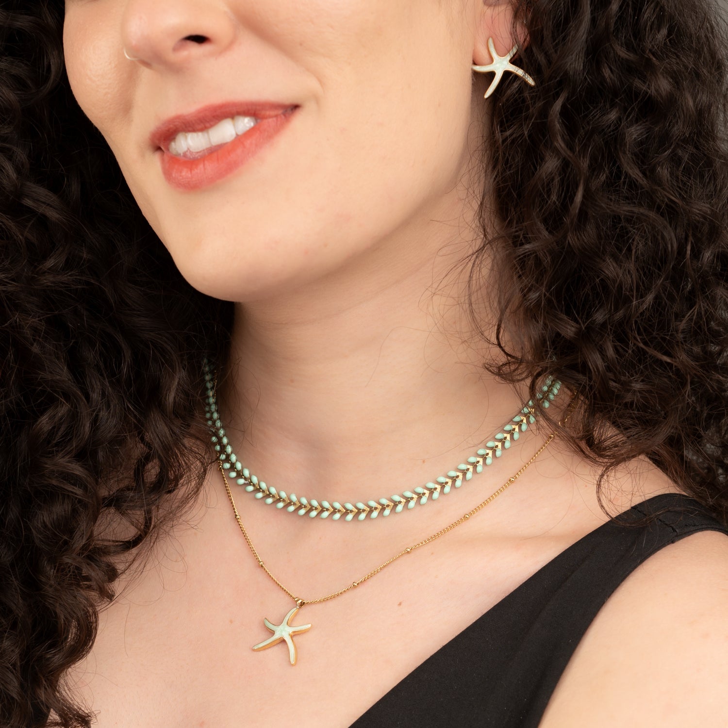 Woman wearing set of mint starfish jewelry, symbolism for starfish, necklace sets, jewelry pairings, gold jewelry sets, best xmas gifts