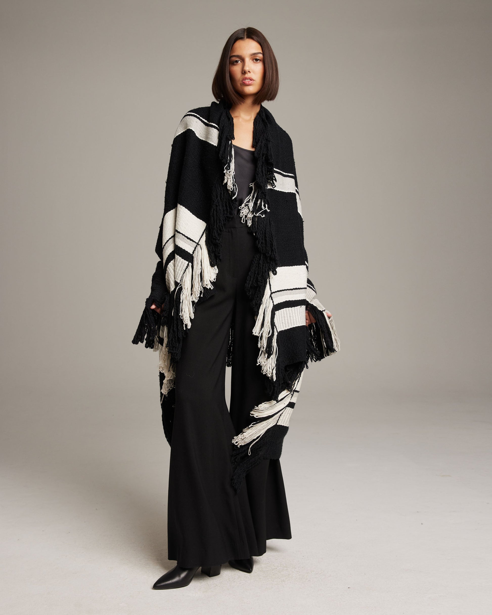 Model wearing Granite Cascade Blanket in Pima Cotton, black and white with fringe