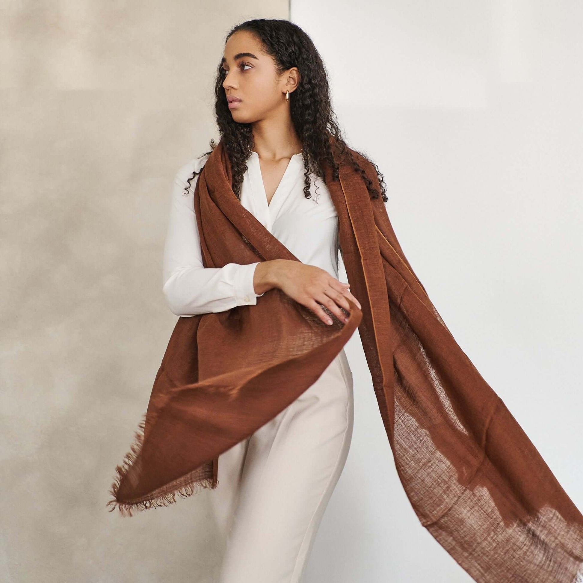 Coco Brown Hand Woven Linen Silk Blend Scarf elegantly styled with a white outfit, showcasing its translucent appeal.
