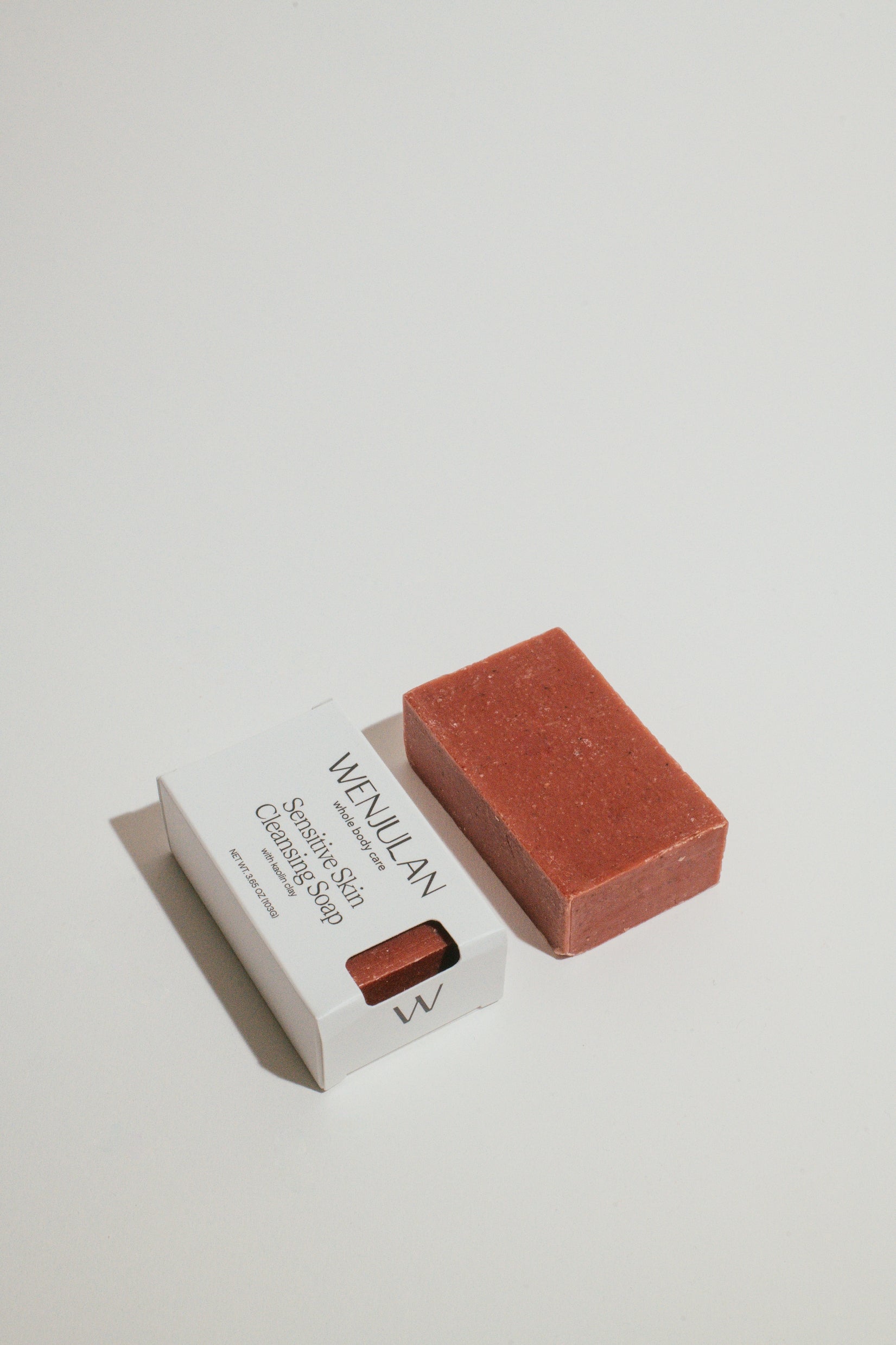 Wenjulan Whole Body Care Sensitive Skin Cleansing Soap with Kaolin Clay bar and front side packaging on a light gray background