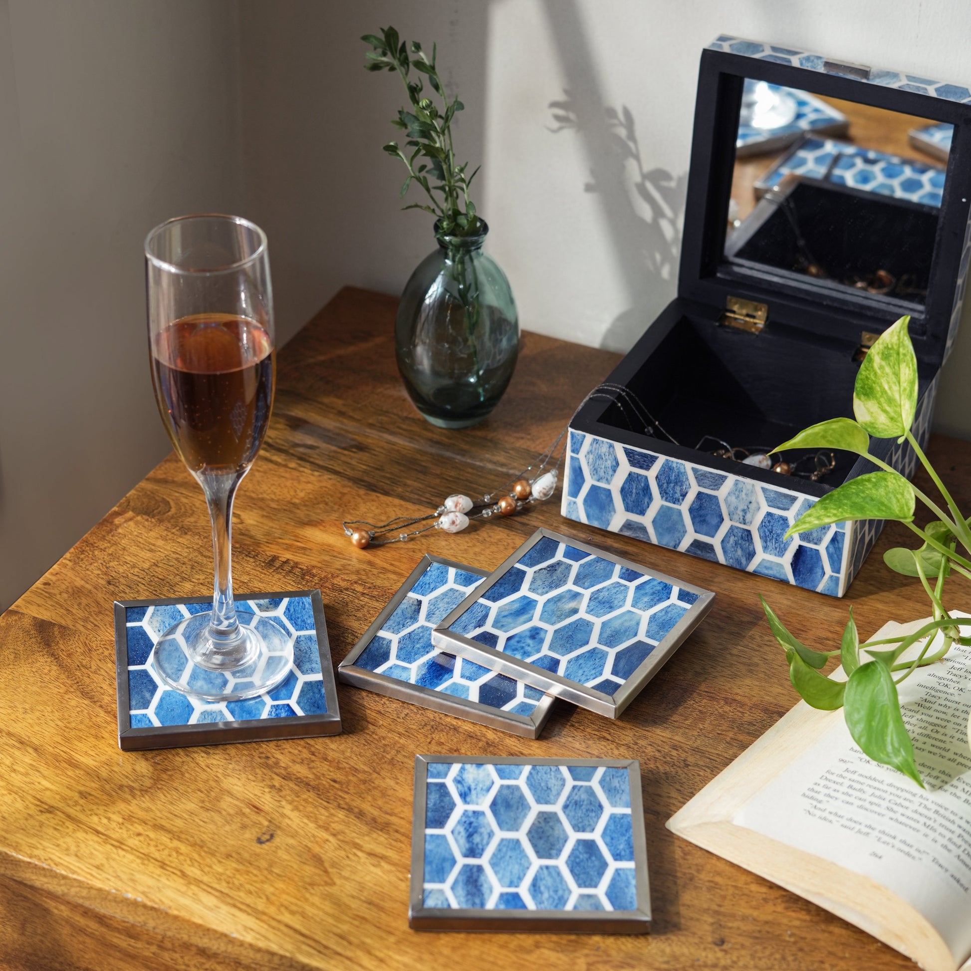 Stack of square indigo blue and white bone inlay coasters showcasing artisanal craftsmanship on a neutral background.