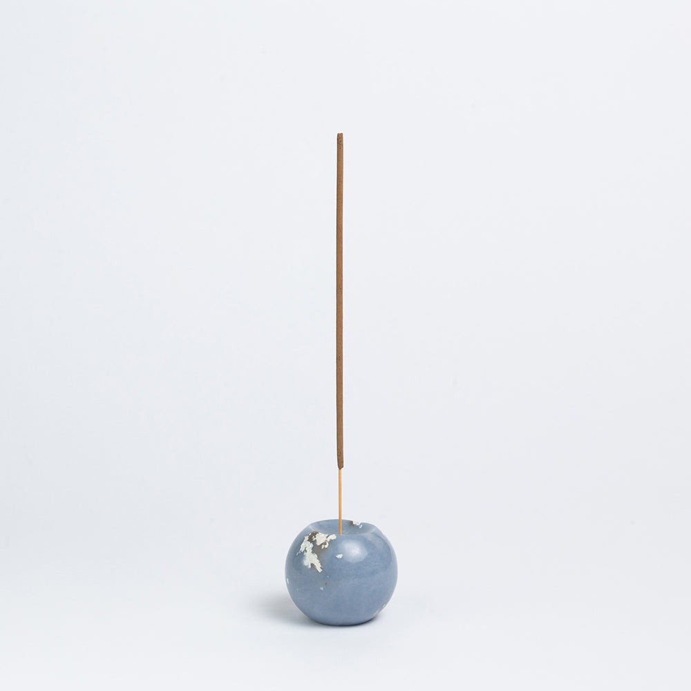 Celestina gemstone sphere incense holder featuring soft blue tones on a white background.