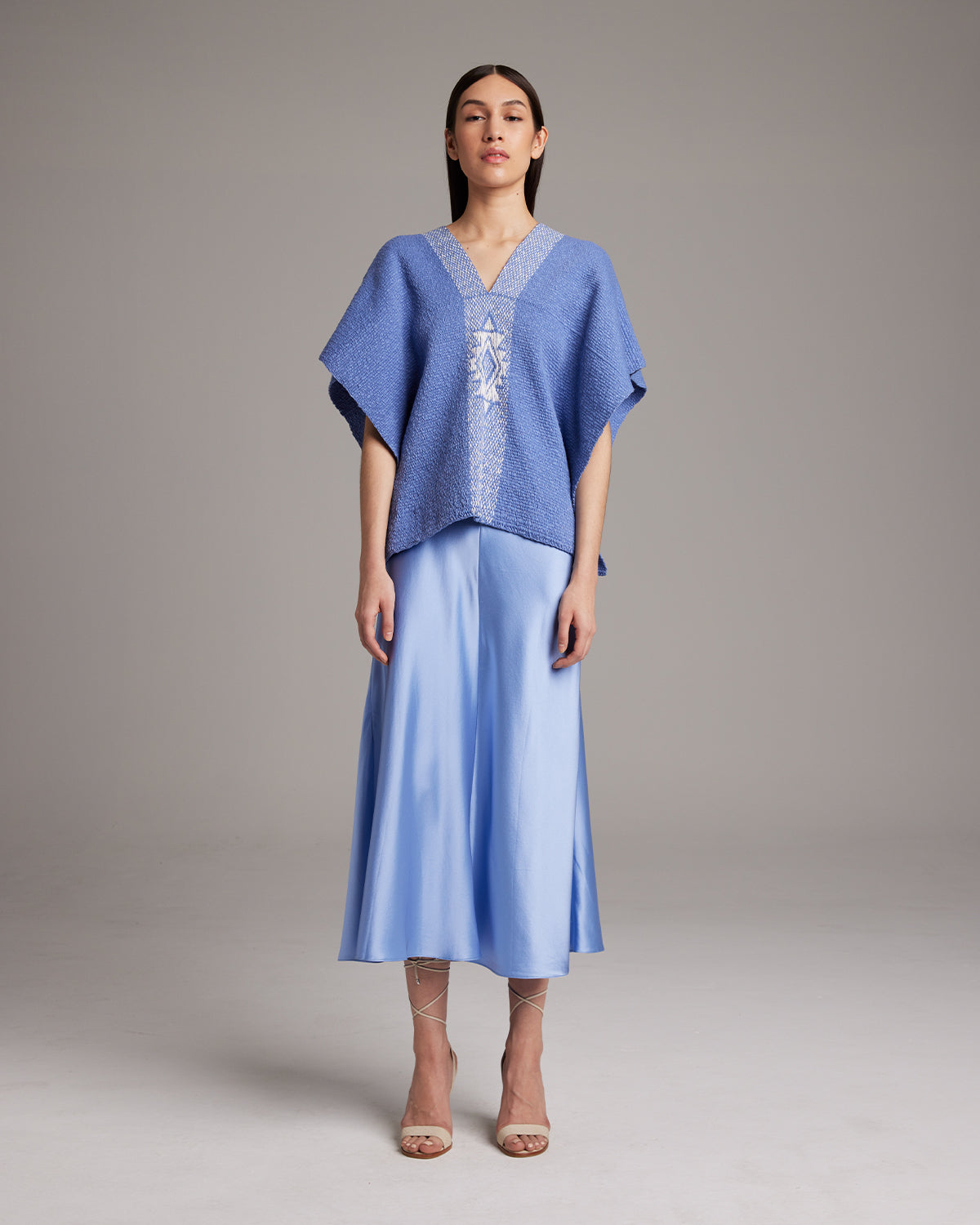 Model wearing a blue Manta Estrella poncho with a textured design