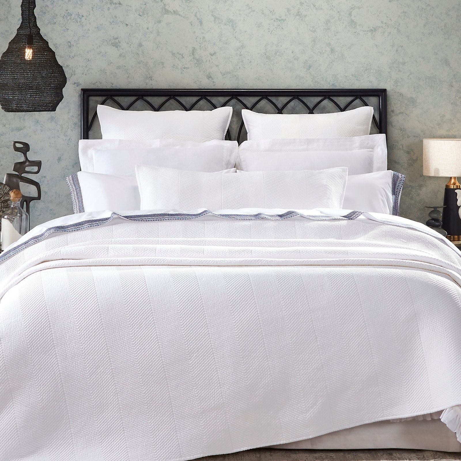 QT-343-9496-LOT1_5|Contemporary white quilt with a distinct chevron herringbone pattern dressing a bed, adding elegant texture to any modern bedroom.