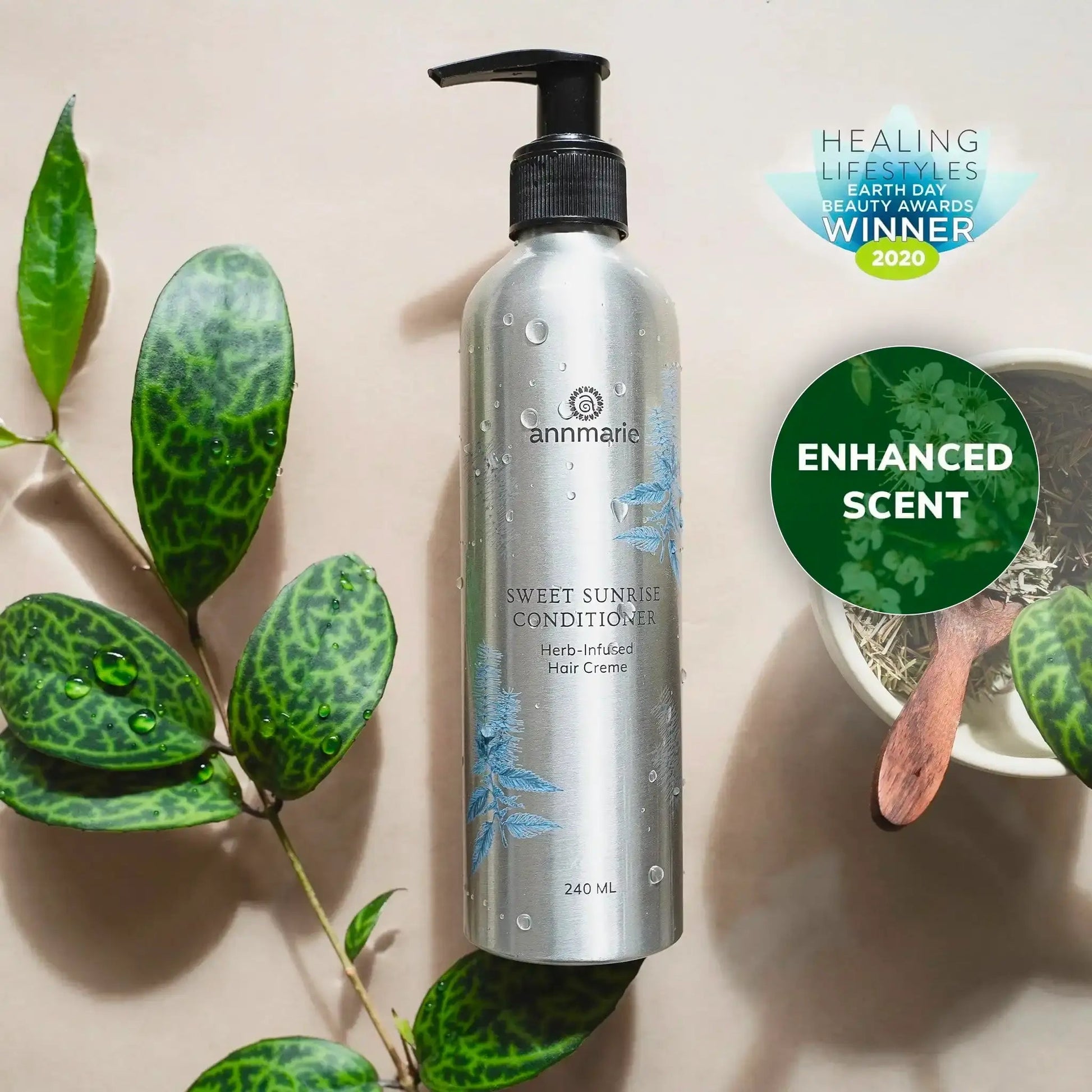 Bottle of Sweet Sunrise Conditioner with green leaves and a bowl on a beige background