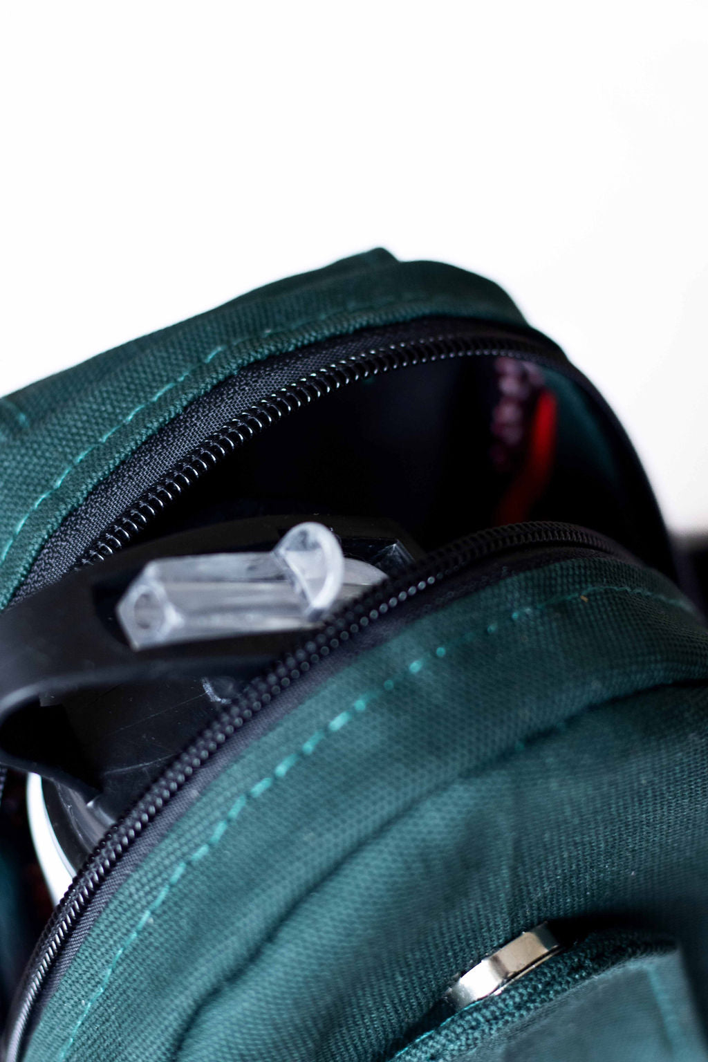Buru canvas sling bag in forest green worn crossbody #color_forest-green