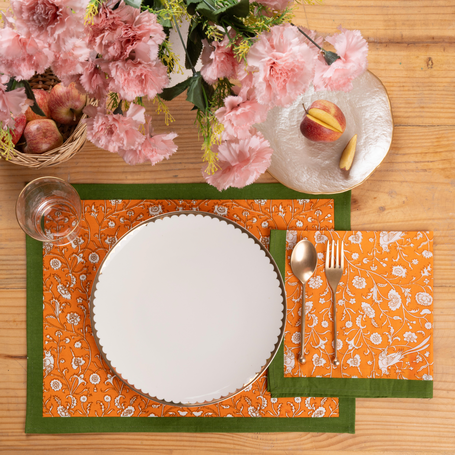 Orange blockprint placemat with bird and floral patterns on wooden table from Inner Child
