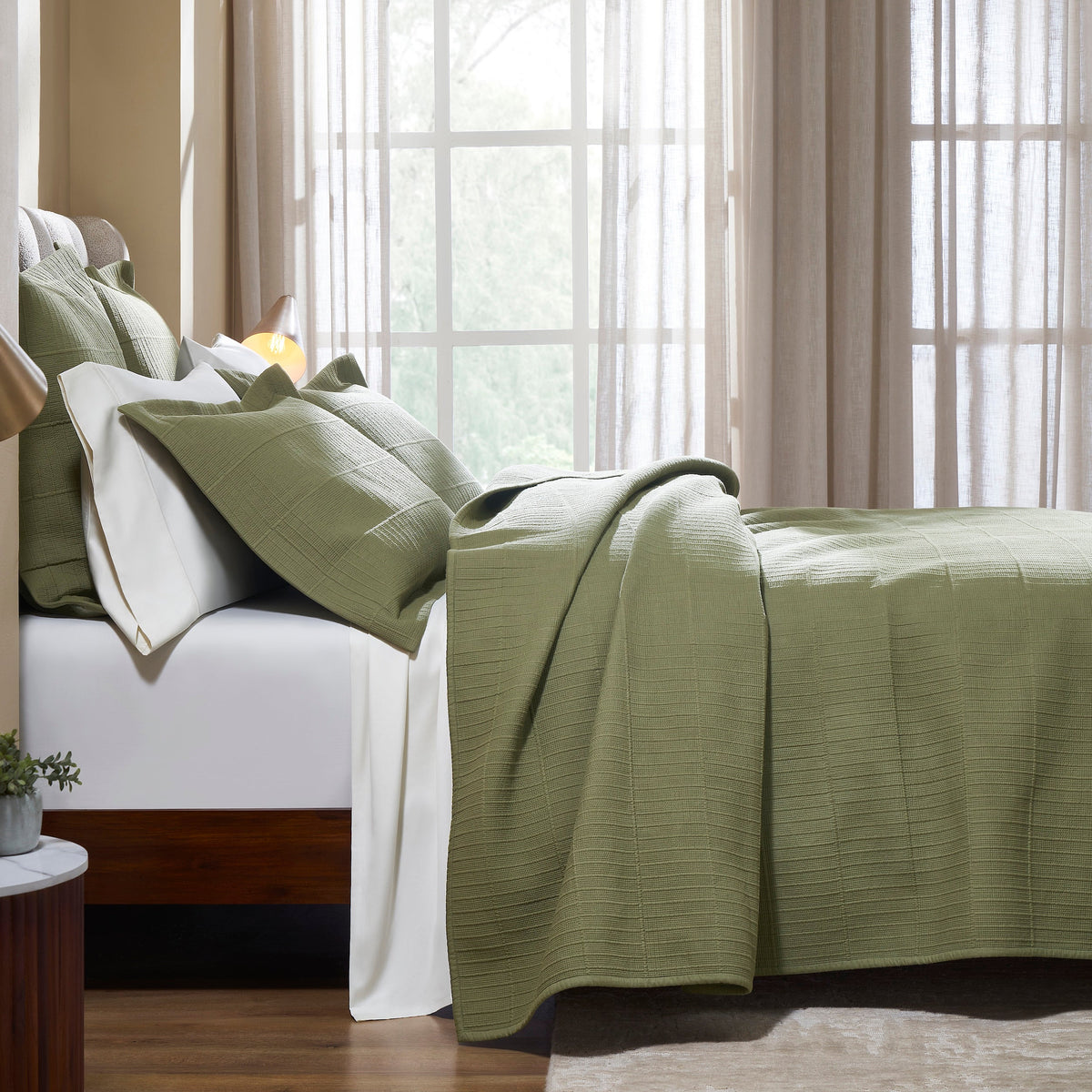 CL-270-11096_3|Side profile of a luxurious sage green coverlet draped over a bed. Breathable, soft layering piece for enhanced comfort.