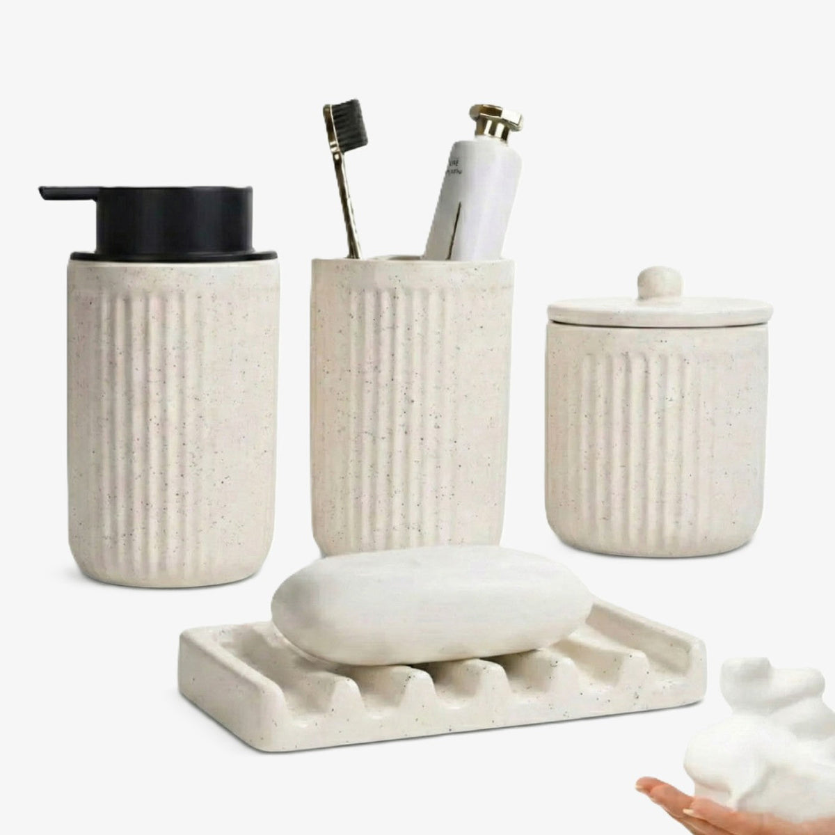 A 4-piece BosilunLife Pockmark bathroom set made of speckled white recycled eco-clay. The collection includes a foaming soap dispenser with a black pump, a ribbed toothbrush holder, a lidded ceramic storage jar, and a sculptural wave-patterned soap dish holding a bar of soap.