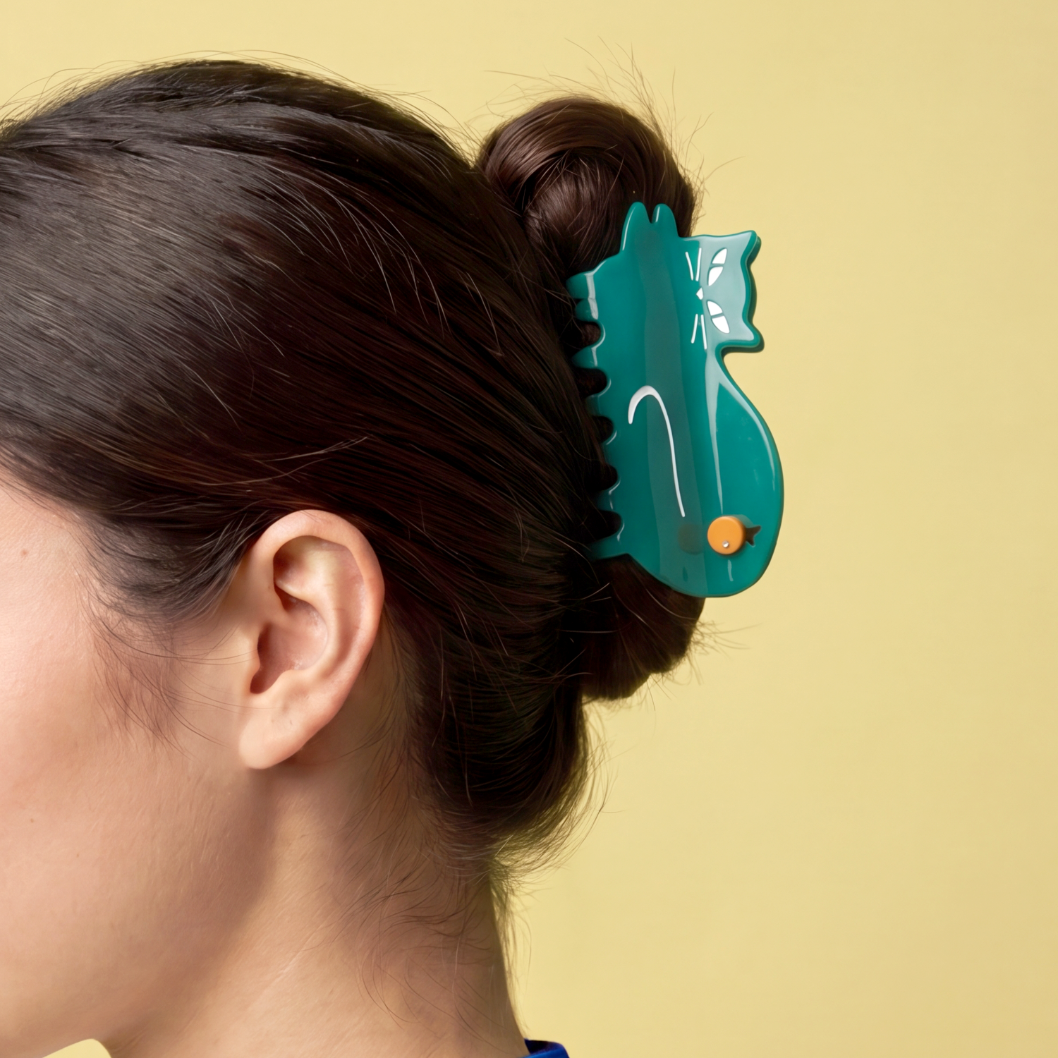 Woman with a green cat hair claw clip on a beige background