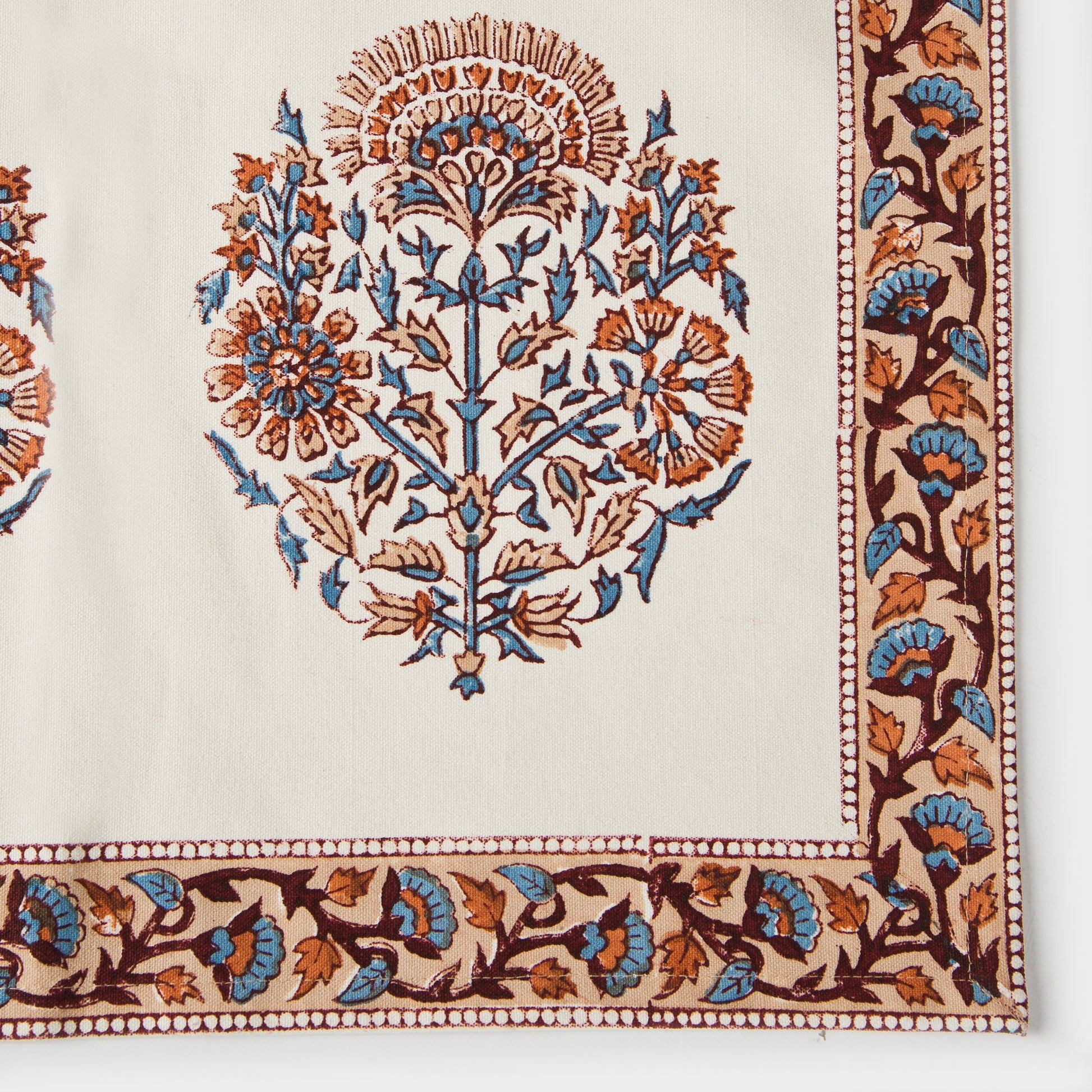 Hand-carved wooden block printed placemats in peach and blue floral design.