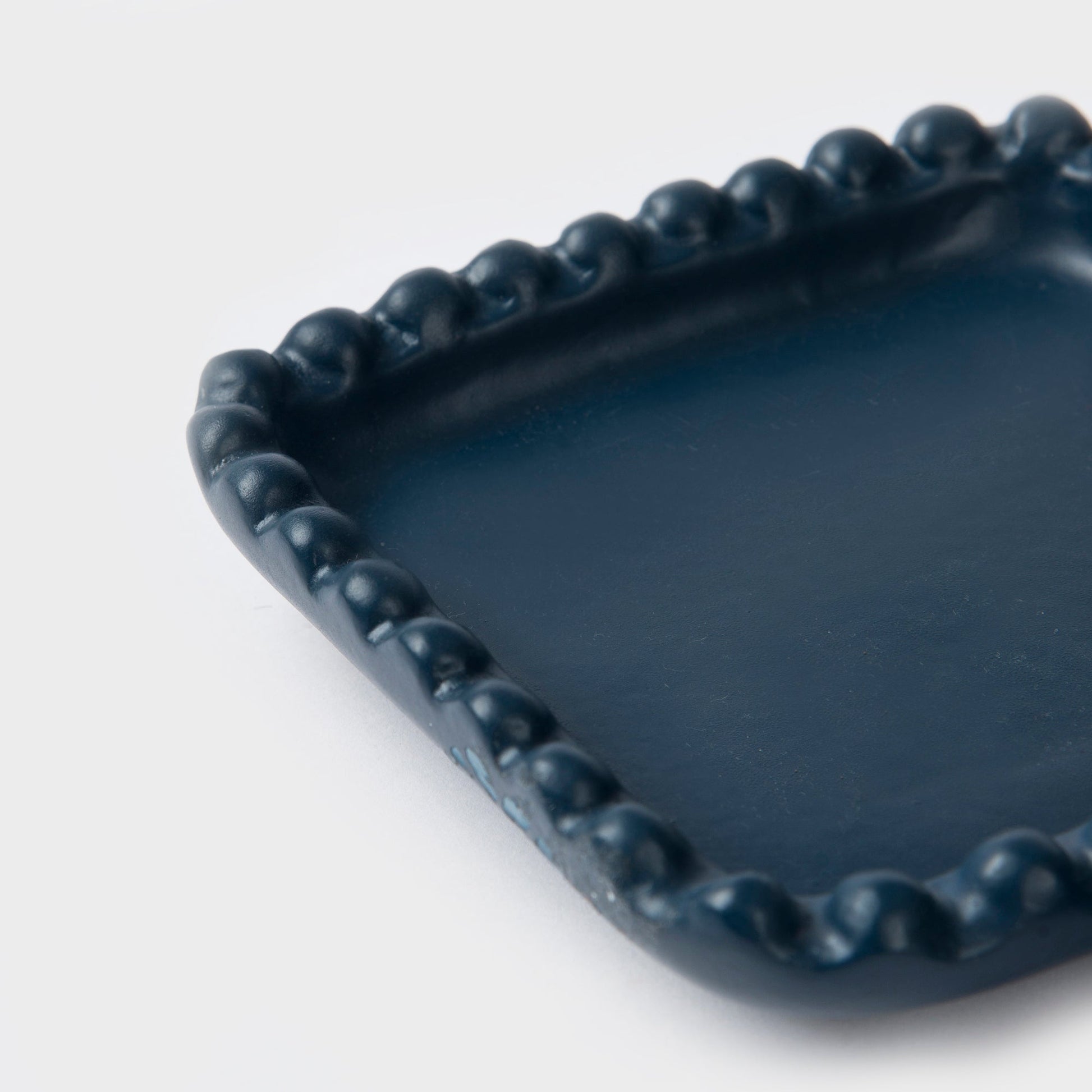  Close-up of beaded edge design and indigo finish on handcrafted terracotta tray