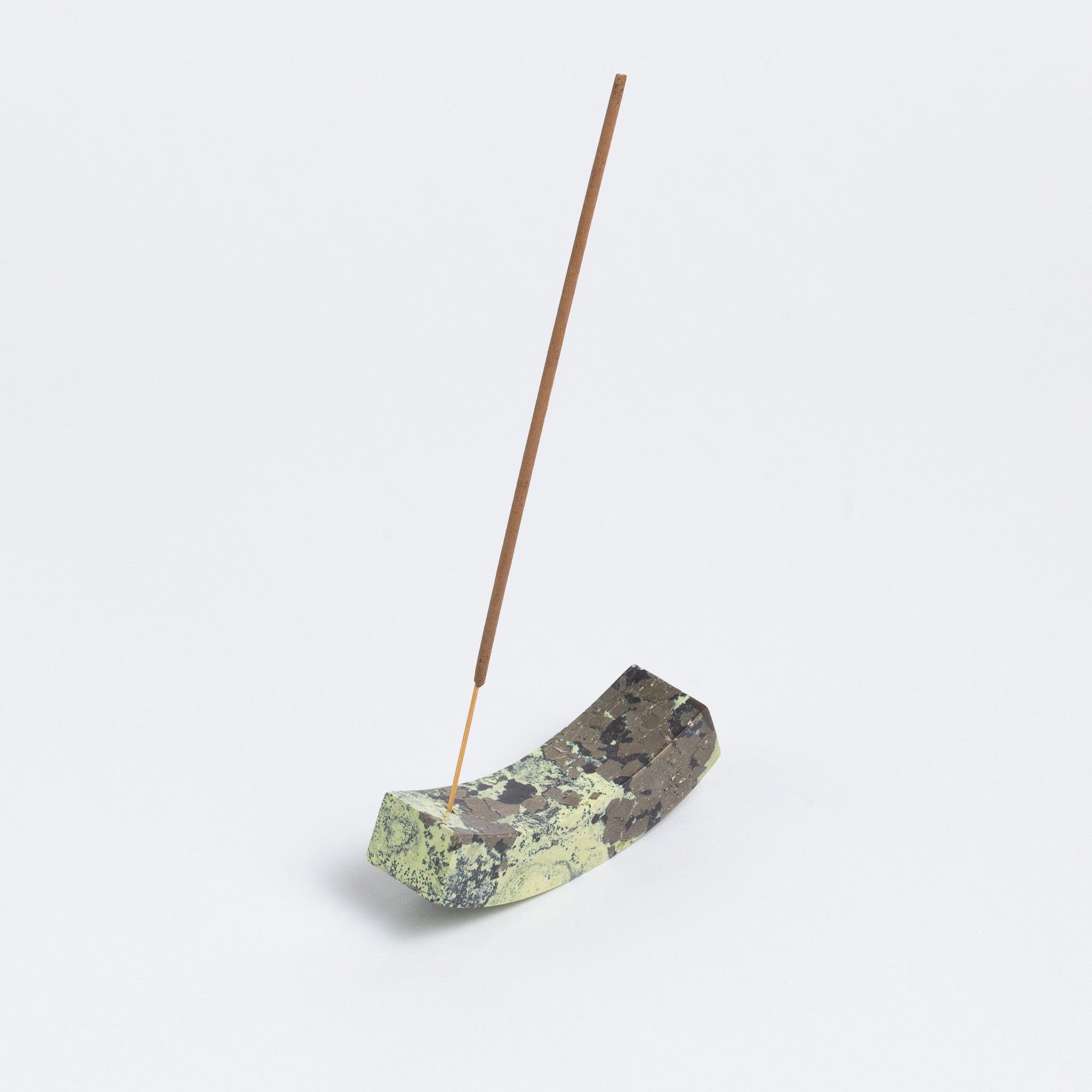 Curved serpentine gemstone incense holder showcasing its rich green tones and natural Andean stone texture on a white background.